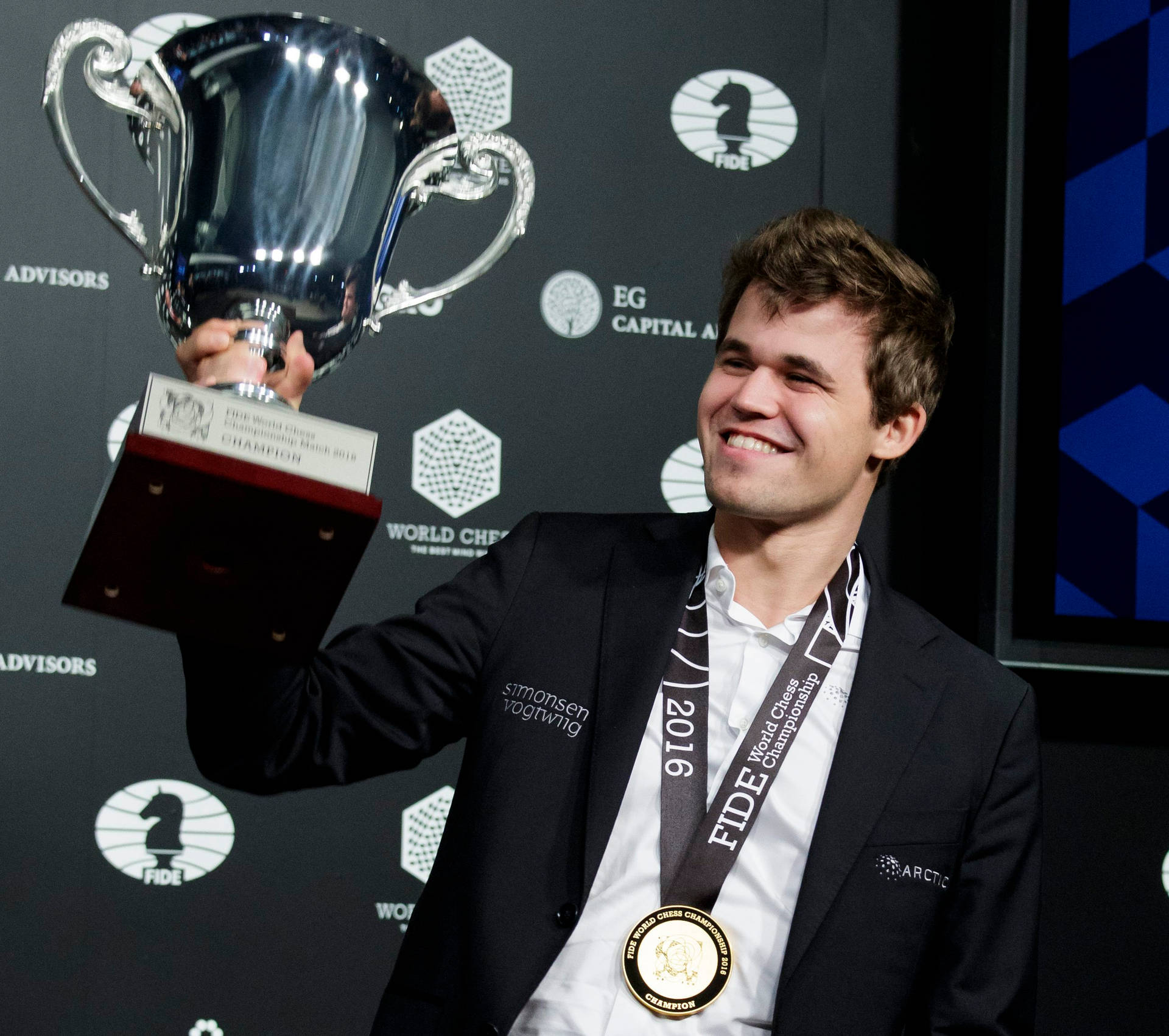 Magnus Carlsen celebrating victory at a chess tournament Wallpaper