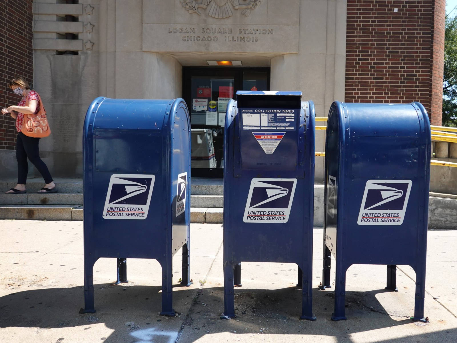 Tre blå posttjenestebokse mod en klar himmel som baggrund. Wallpaper