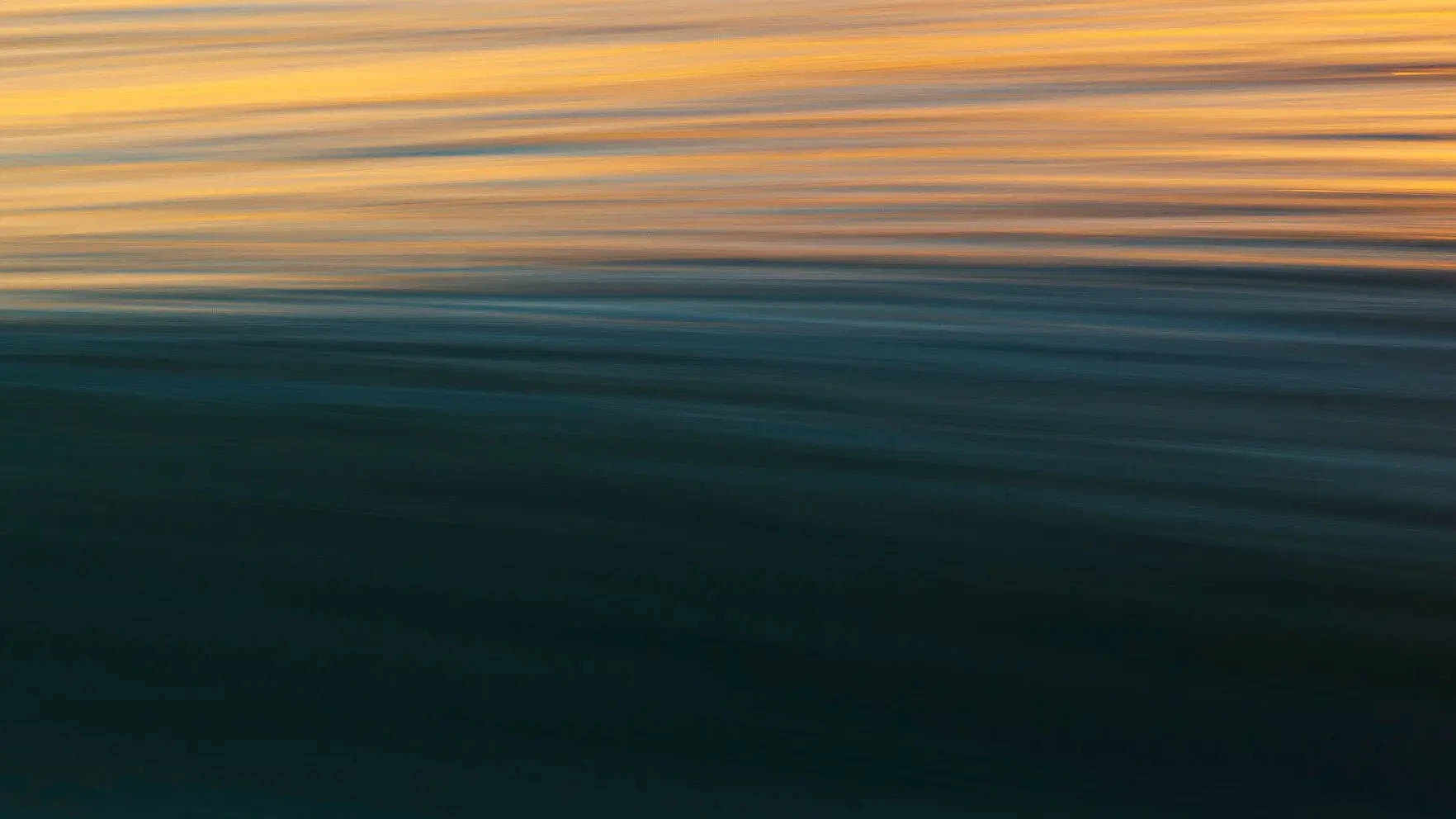 Majestic Golden Sunrise Over The Serene Blue Ocean Wallpaper