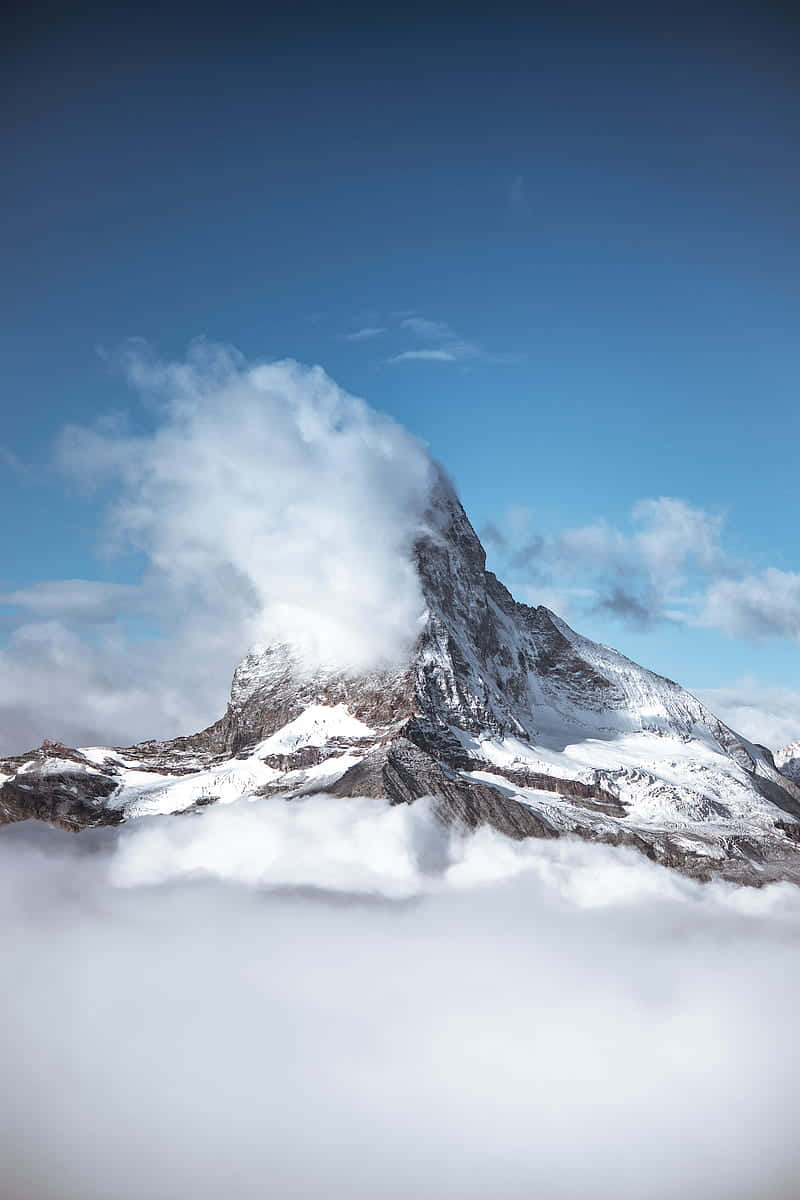 Majestic_ Mountain_ Peak_ Above_ Clouds.jpg Wallpaper