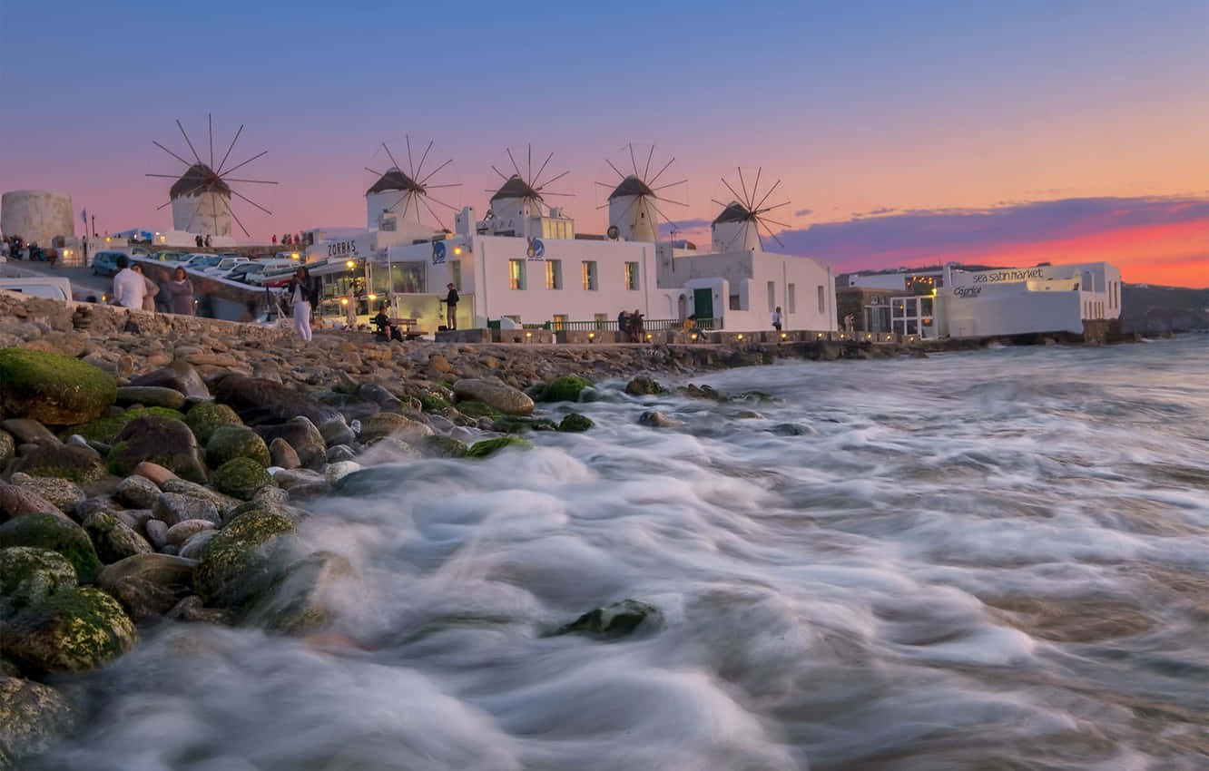 Majestic Mykonos Windmills Against The Backdrop Of The Stunning Sunset. Wallpaper