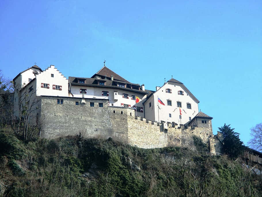 Majestic Vaduz Castle Perched On A Hill Against Dramatic Sky Wallpaper