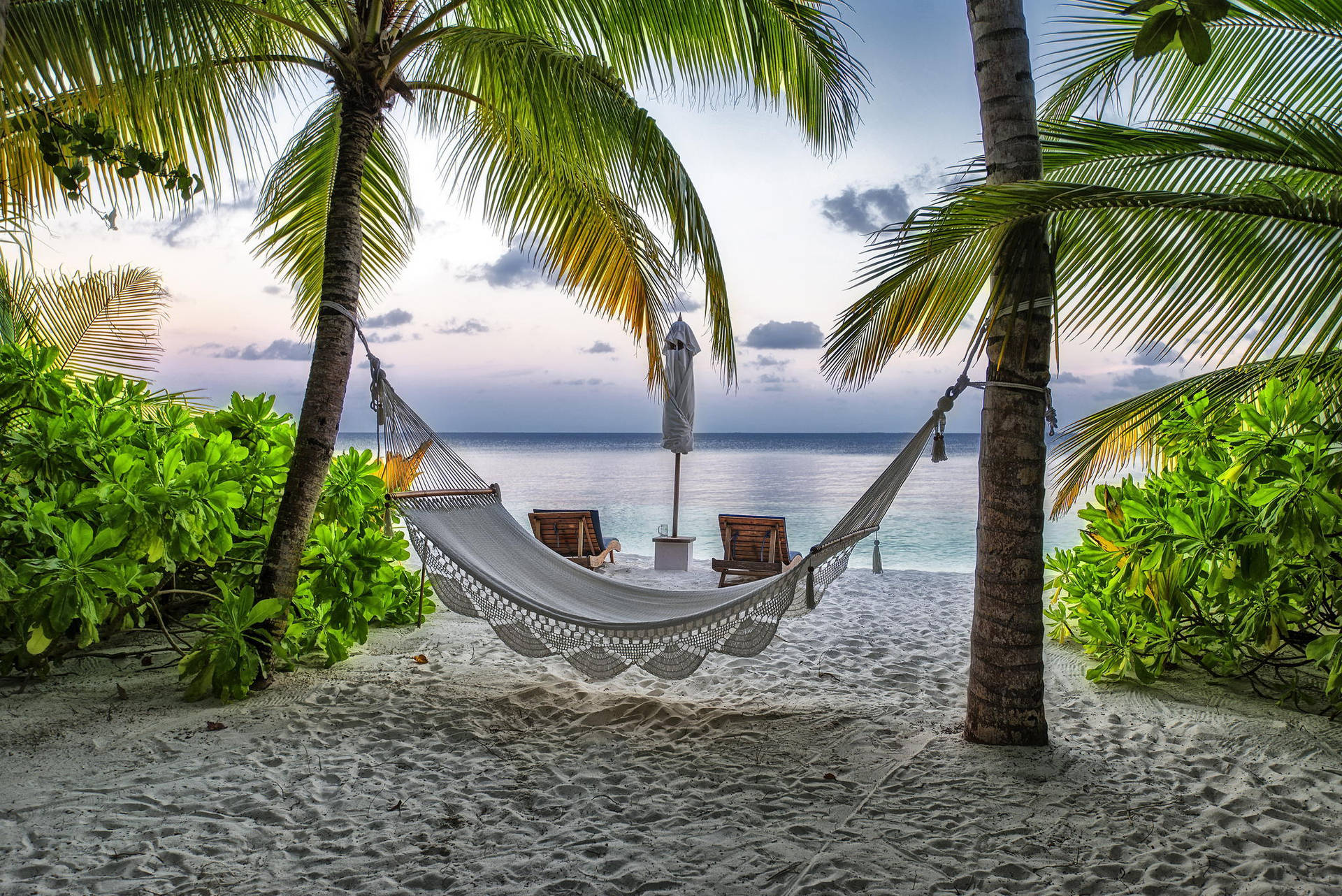 Caption: Captivating Maldives Beach with a Comfortable Hammock Wallpaper
