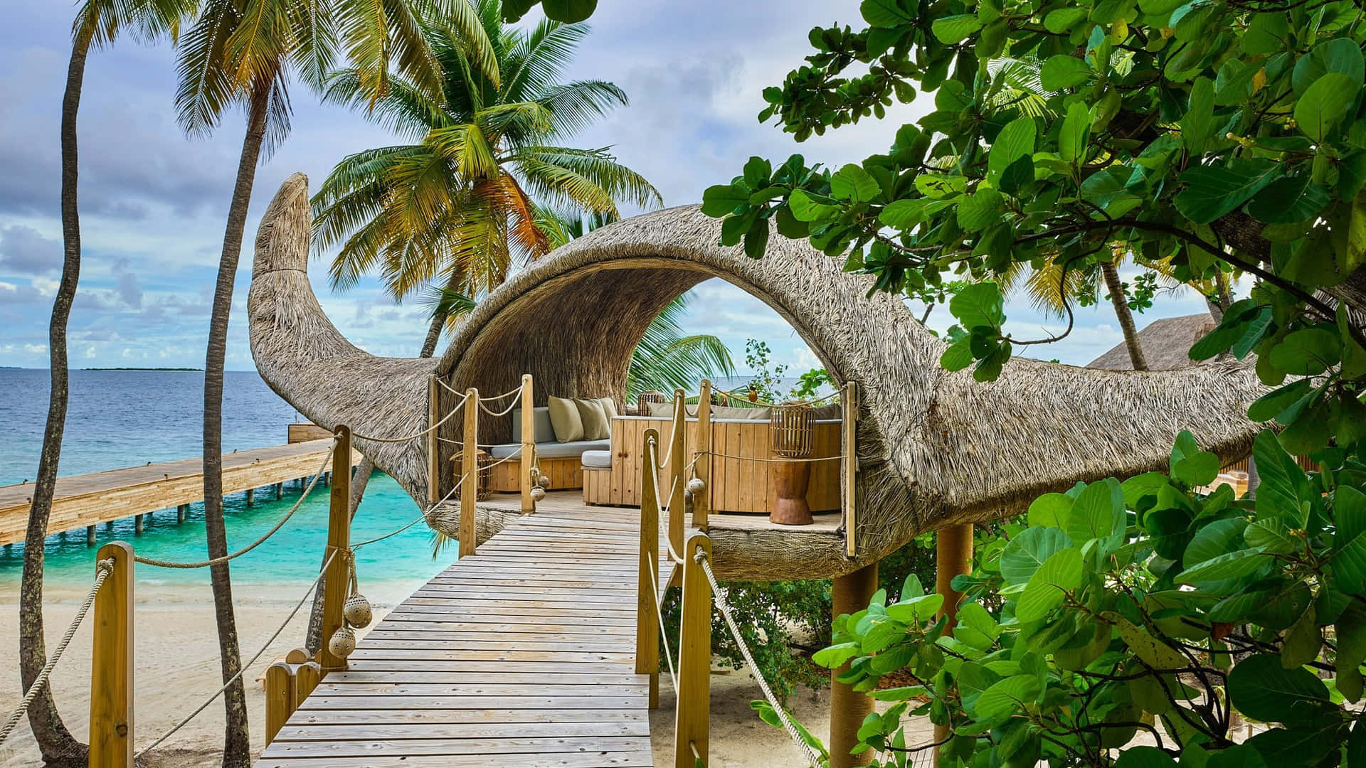 A Wooden Walkway Leading To A Tree House On The Beach