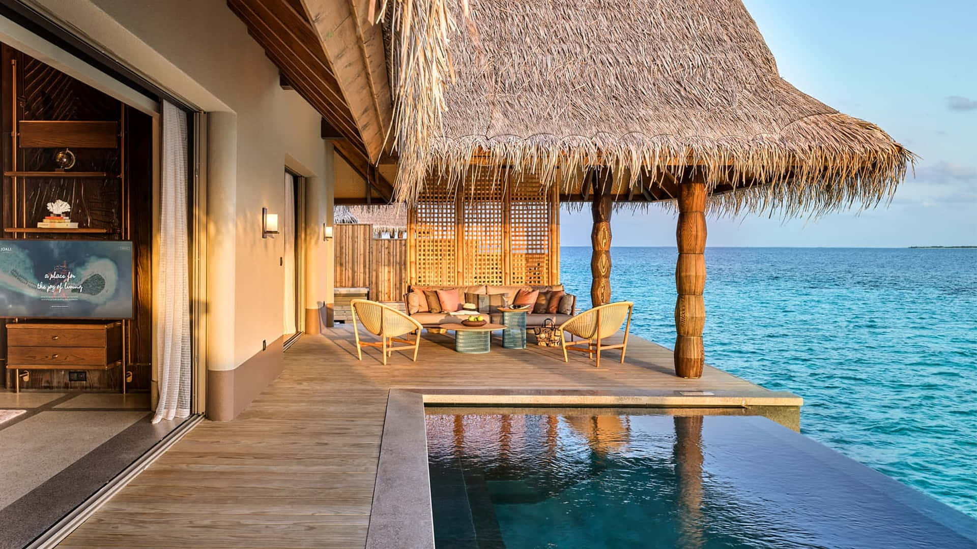 A Villa With A Pool And Thatched Roof Overlooking The Ocean
