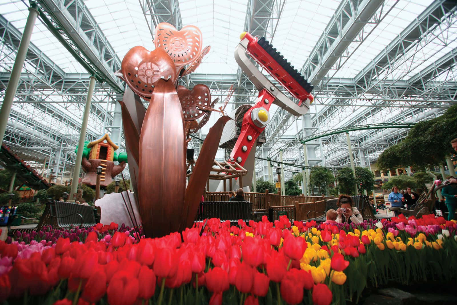 A Large Indoor Garden With Tulips And A Sculpture