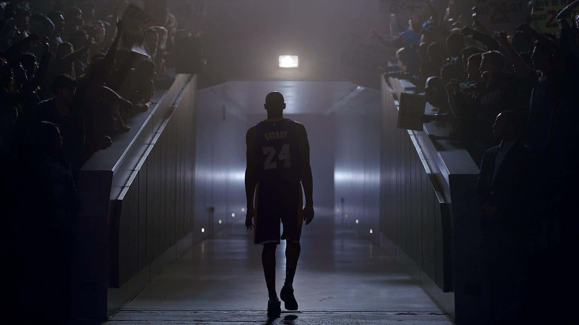 A Basketball Player Walks Down A Hallway With A Crowd Wallpaper