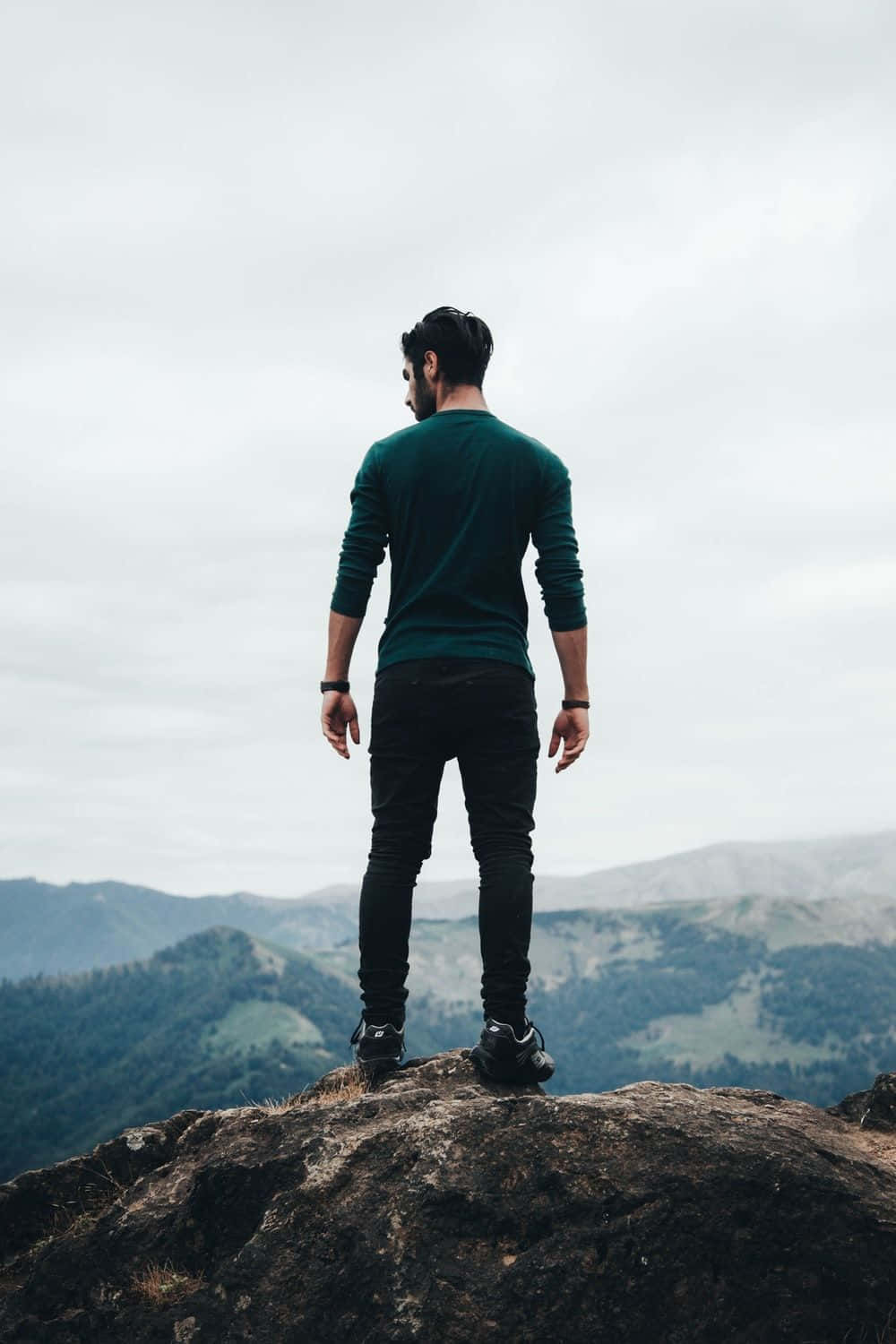 Man Standing On Top Of A Mountain