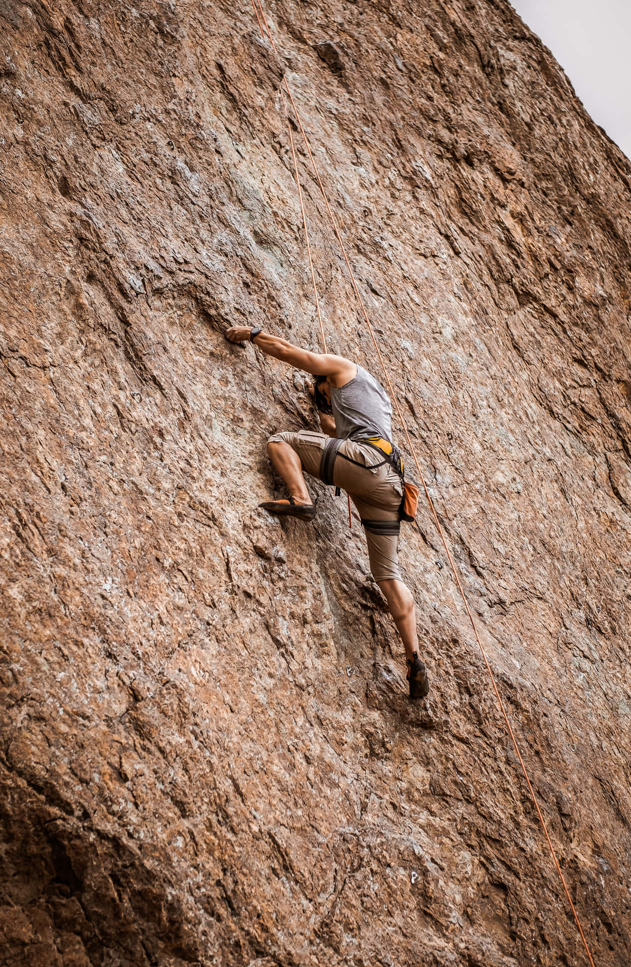 Man Doing Arduous Free Climbing Wallpaper