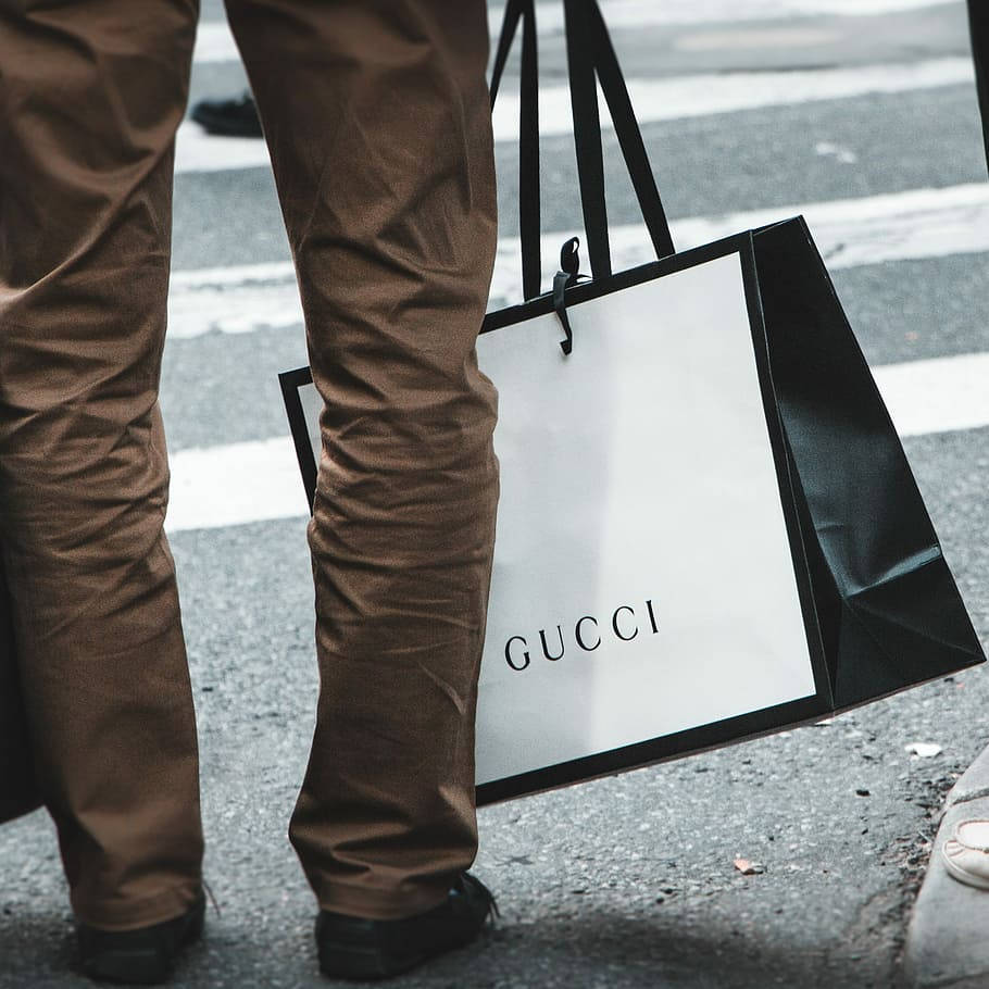 Hombresosteniendo Una Bolsa Gucci 4k Fondo de pantalla