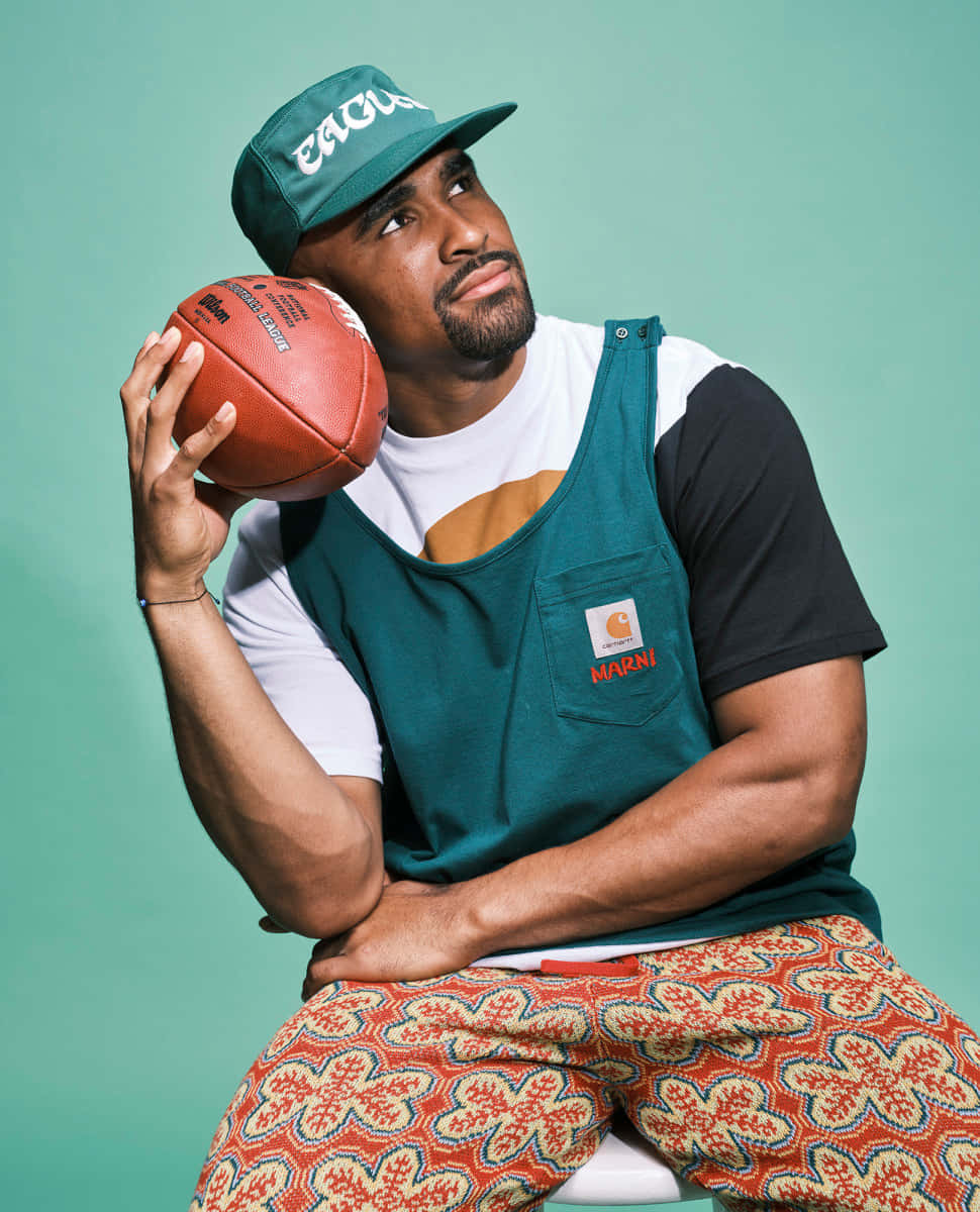 Man Holding Football Stylish Outfit Wallpaper