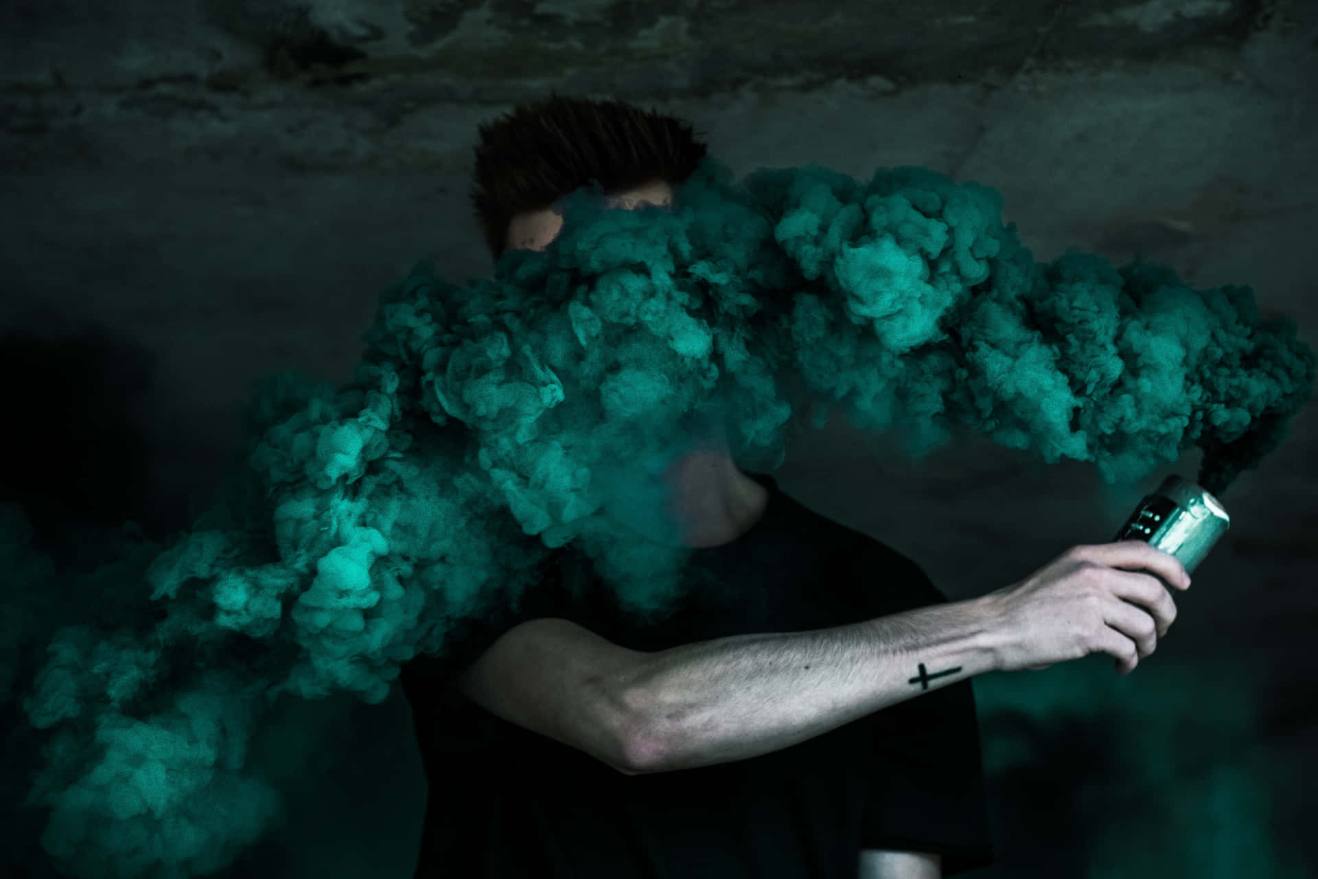 Man Holding Intense Green Smoke Bomb Wallpaper