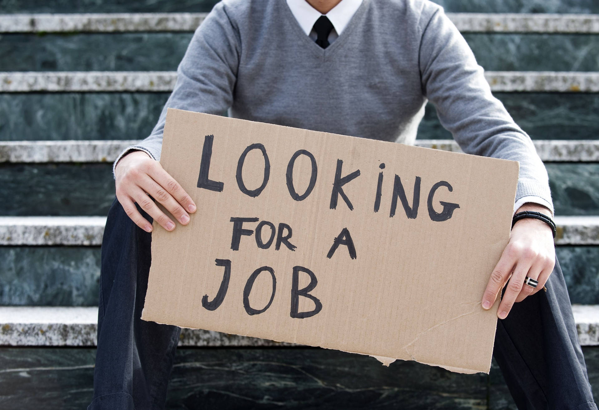 En mand med skilte relateret til arbejdsløshed Wallpaper