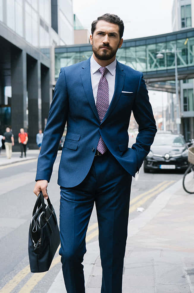 A Man In A Blue Suit Walking Down The Street