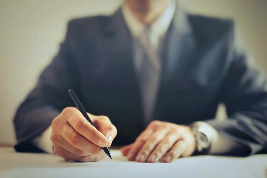 Man In Suit Signing Contract Documents Wallpaper