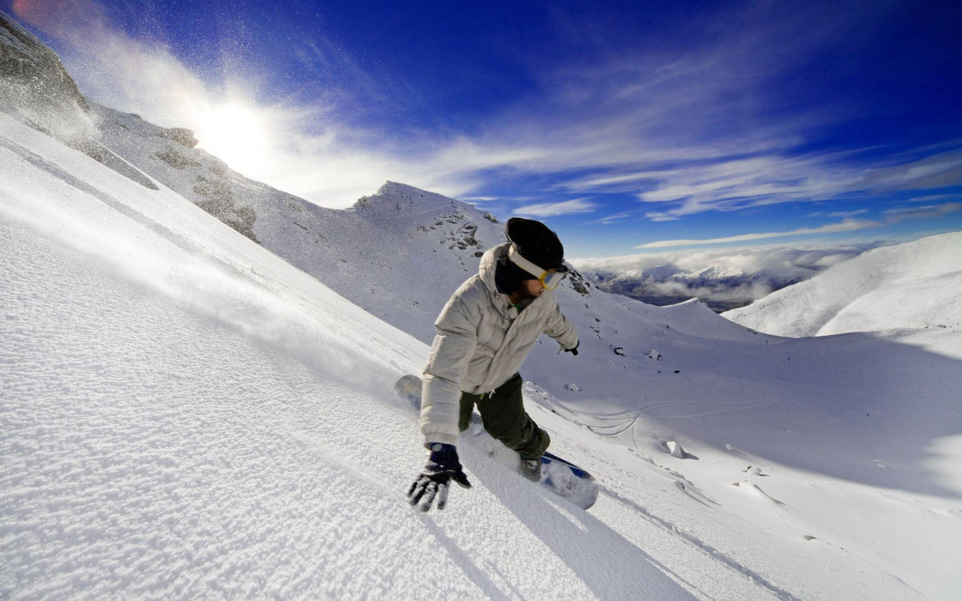 Man In White With Snowboard Descending A Slope Background