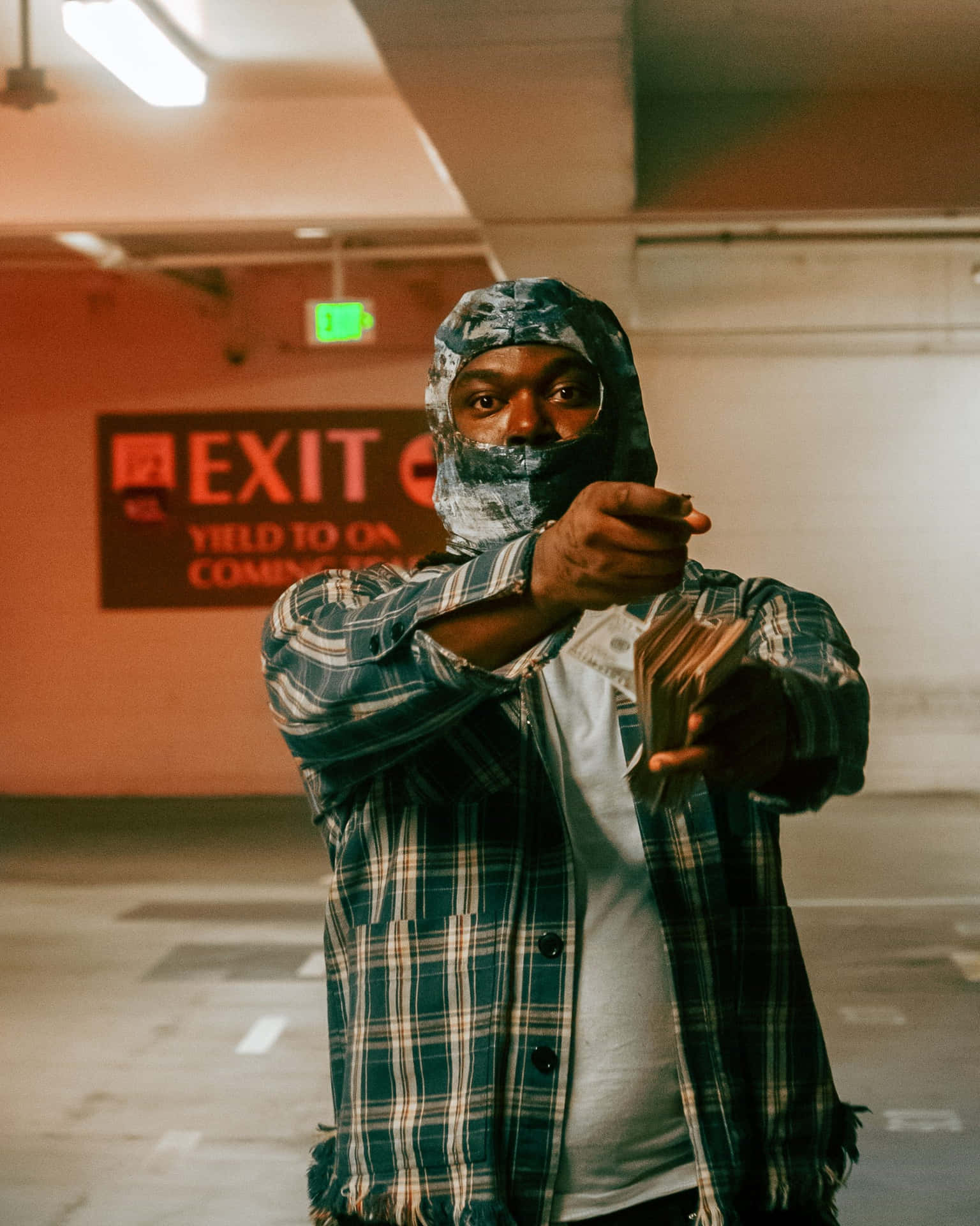 Man Pointing Gunin Parking Garage Wallpaper