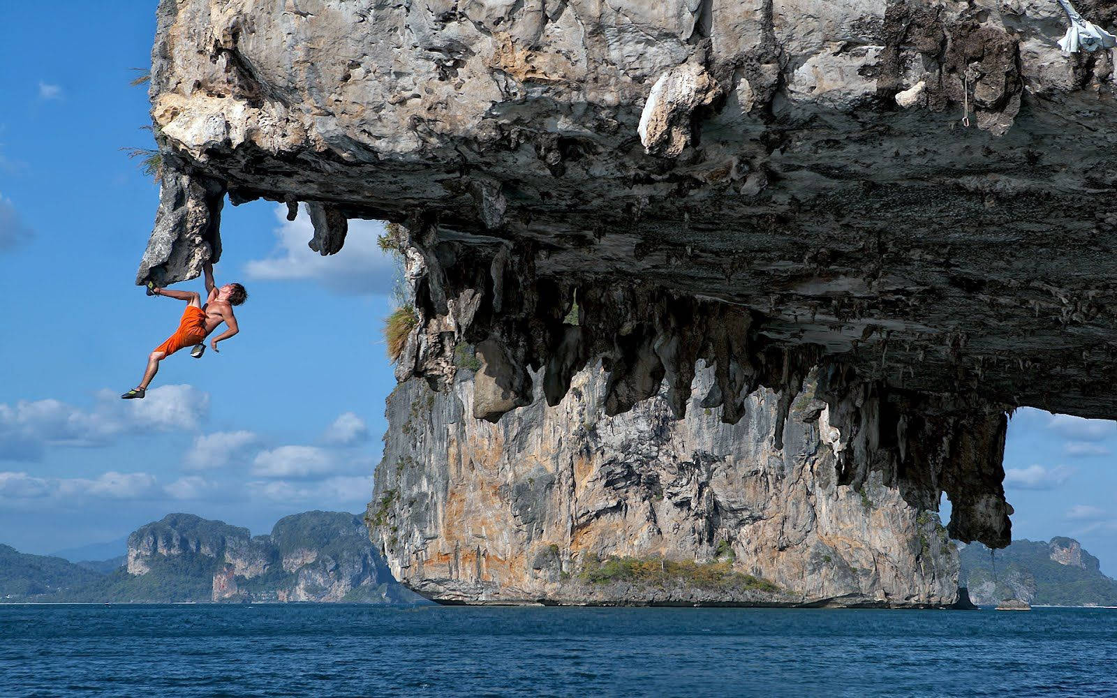 Man Rock Climbing Over The Sea Wallpaper