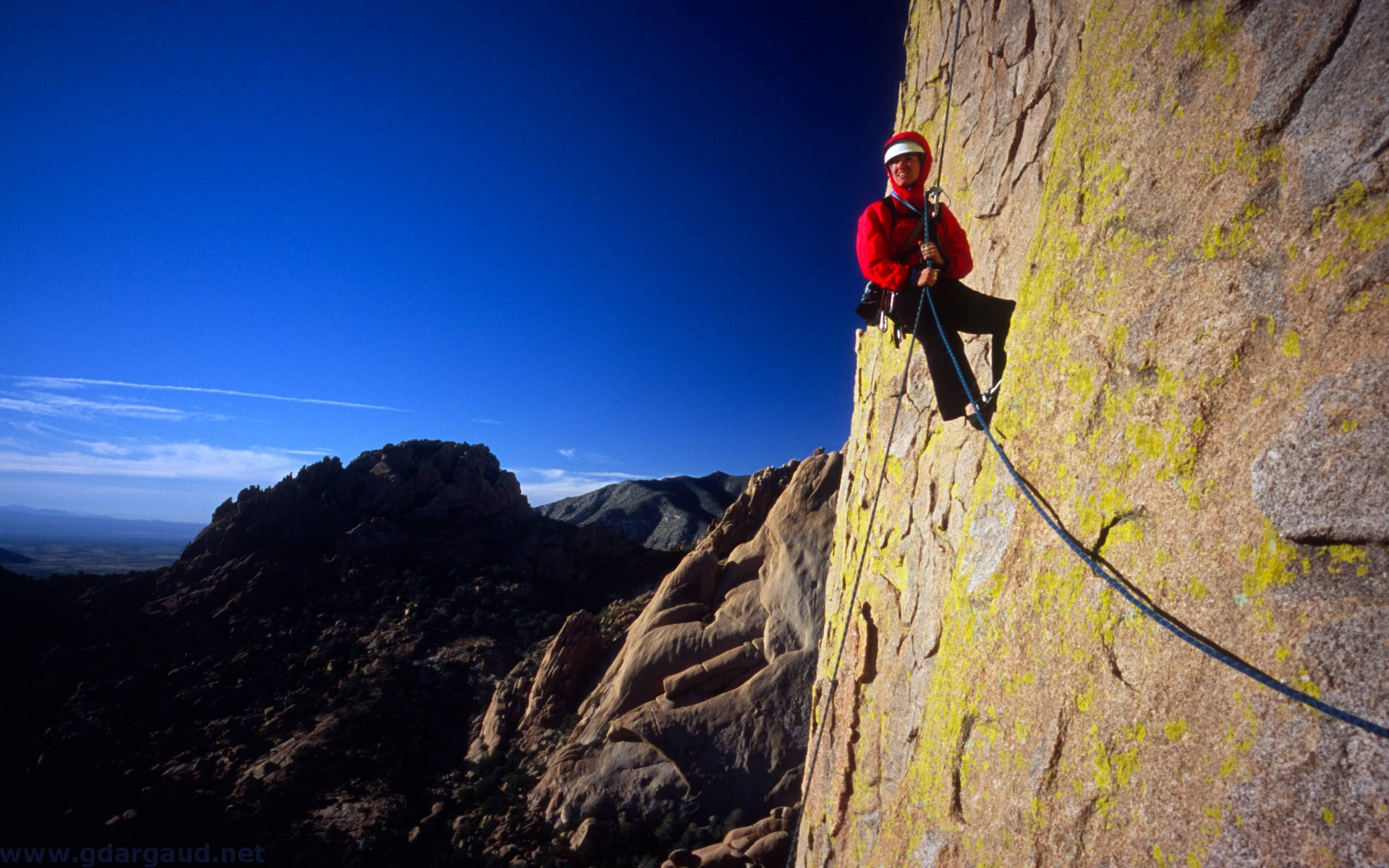 Man Rock Climbing While Holding A Rope Wallpaper