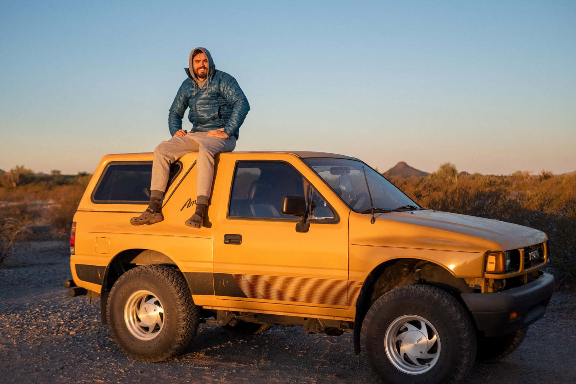 Man Zittend Op Gele Isuzu Amigo Bij Dusk Achtergrond