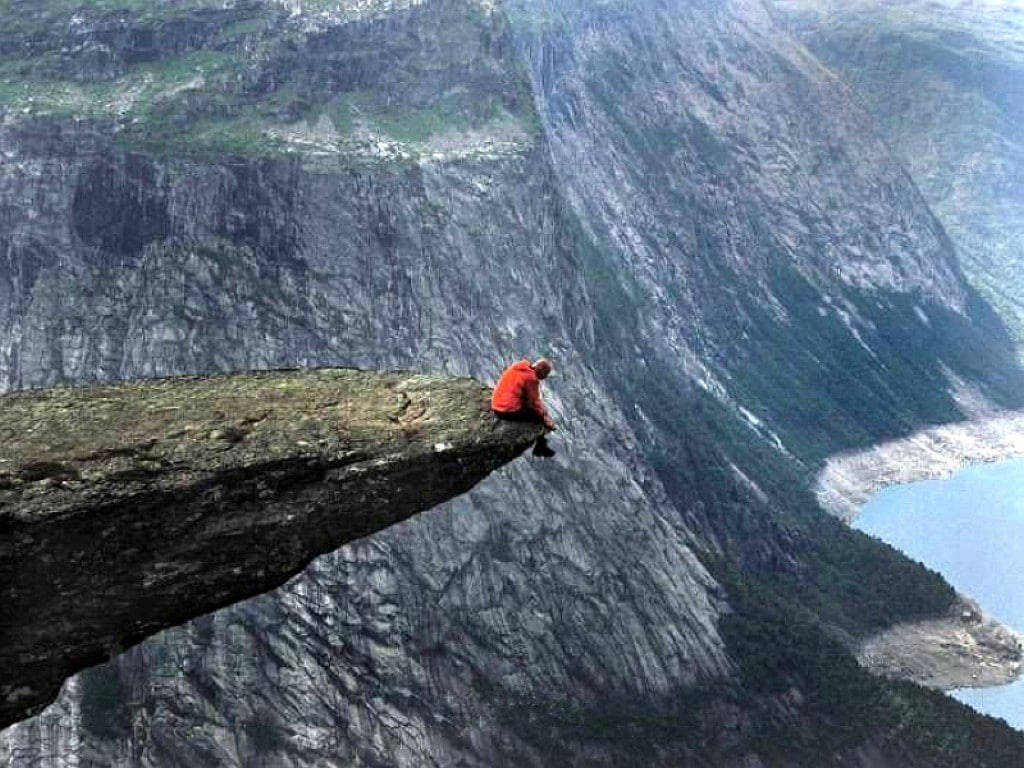 Man Sitting Alone At Cliff Edge Wallpaper