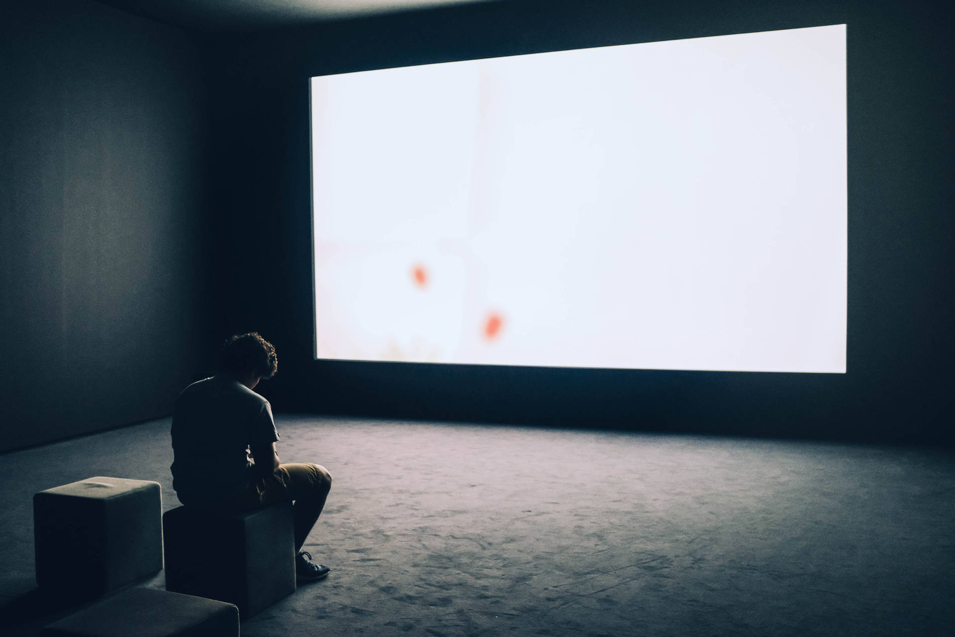 Man Sitting Alone In Theater Room Wallpaper