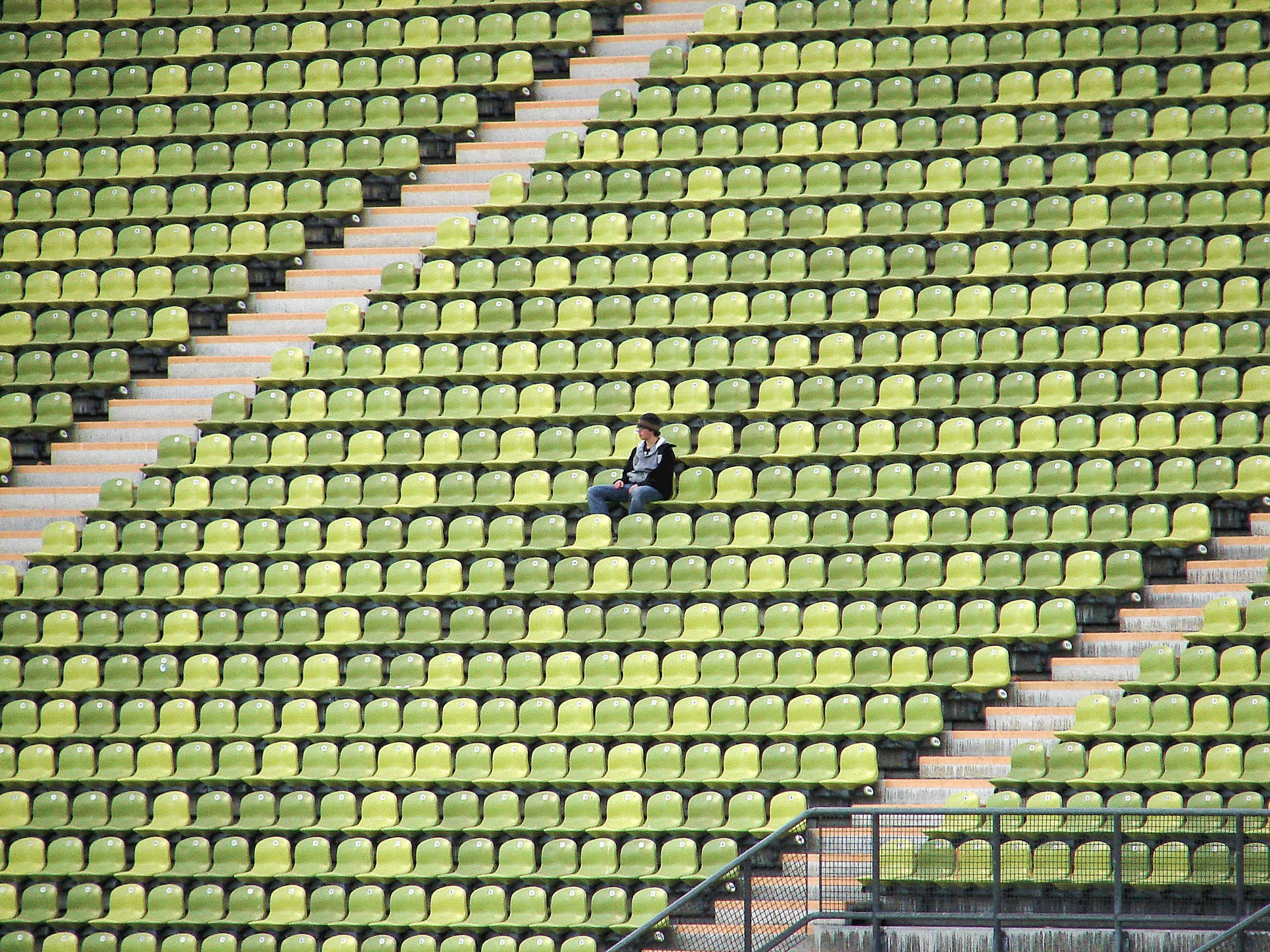 Man Sitting Alone On Stadium Seat Background