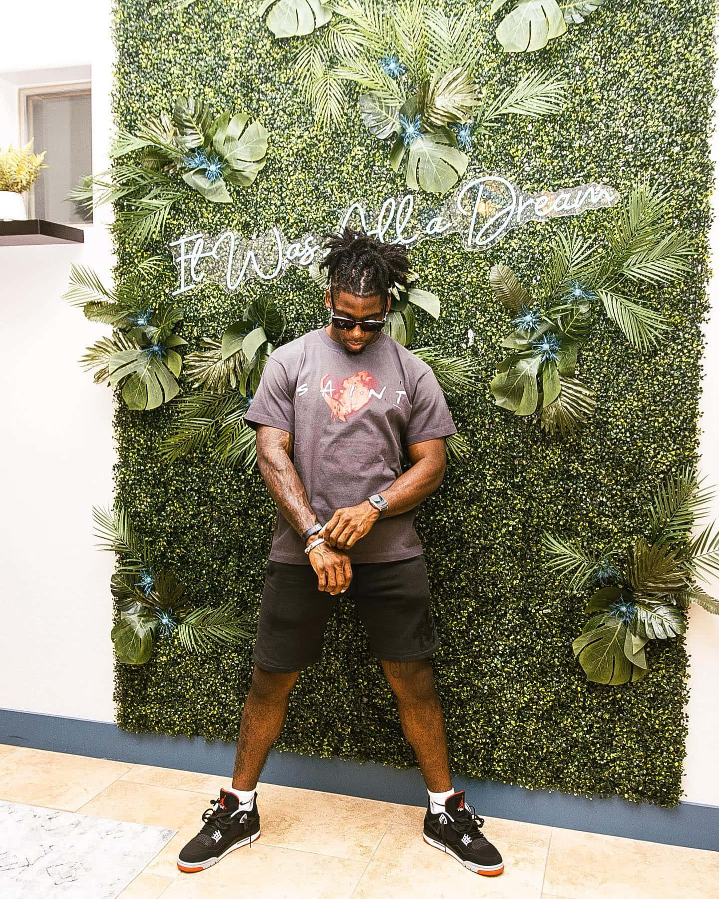 Man Standing Against Leafy Backdrop Wallpaper