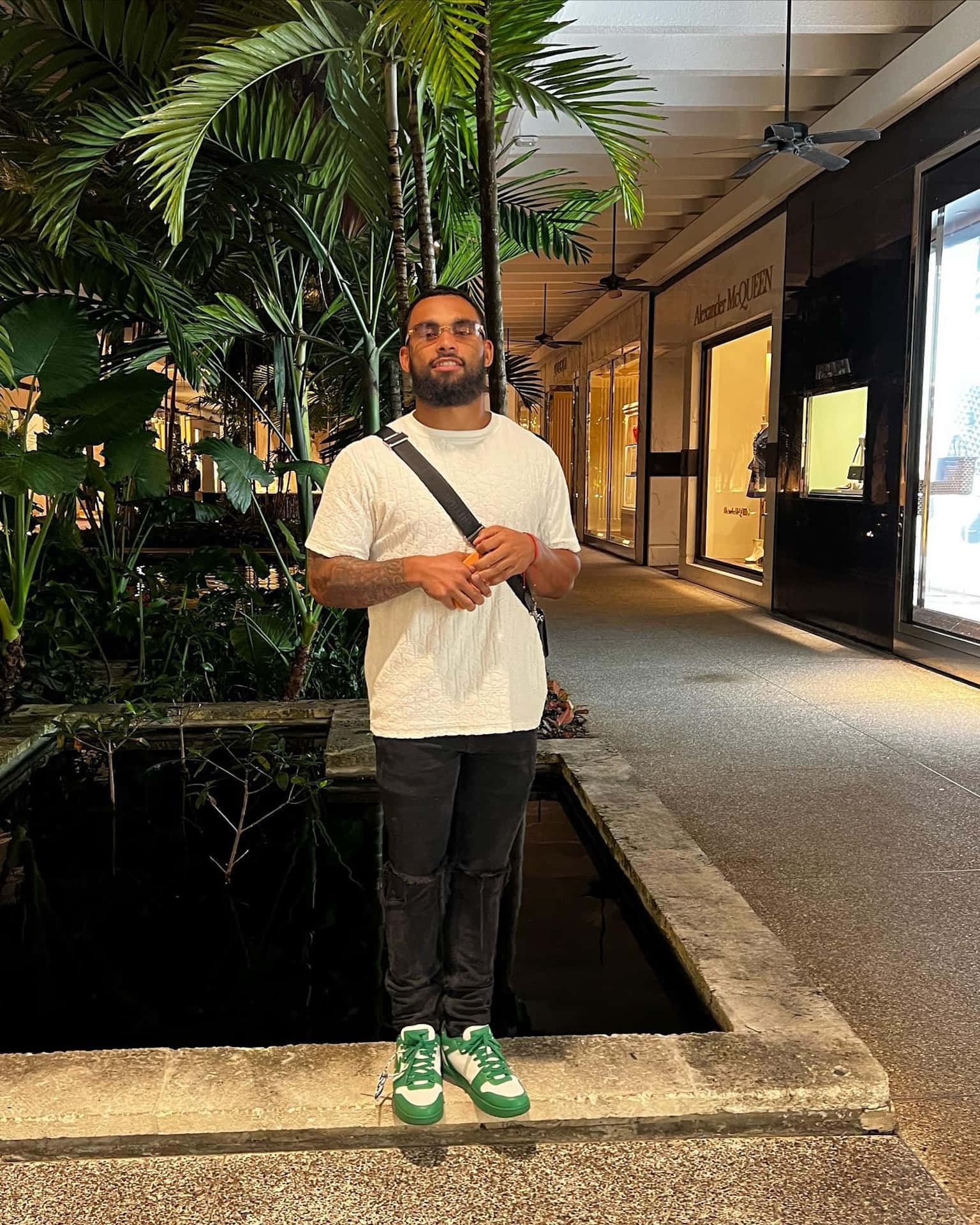 Man Standing Near Tropical Plants Mall Wallpaper