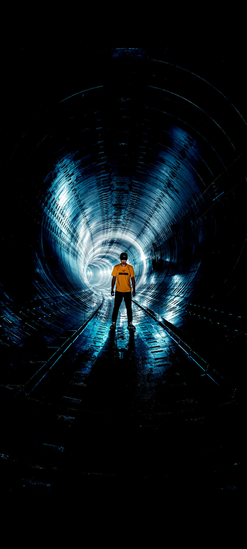 Man Standingin Illuminated Tunnel Wallpaper