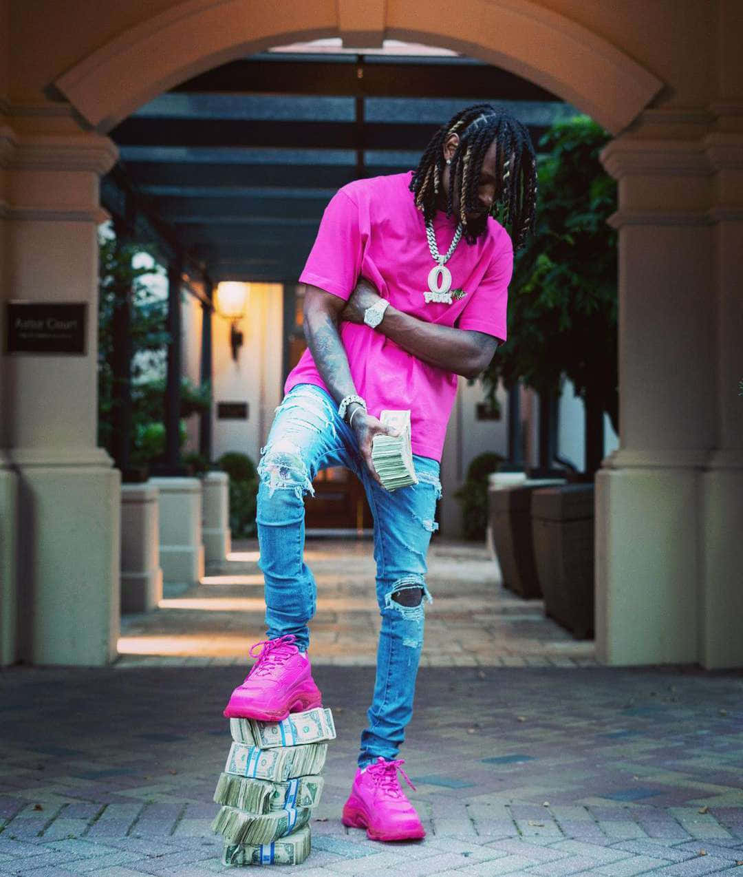 Man Standingon Money Stacks Wearing Pink Shirt Wallpaper