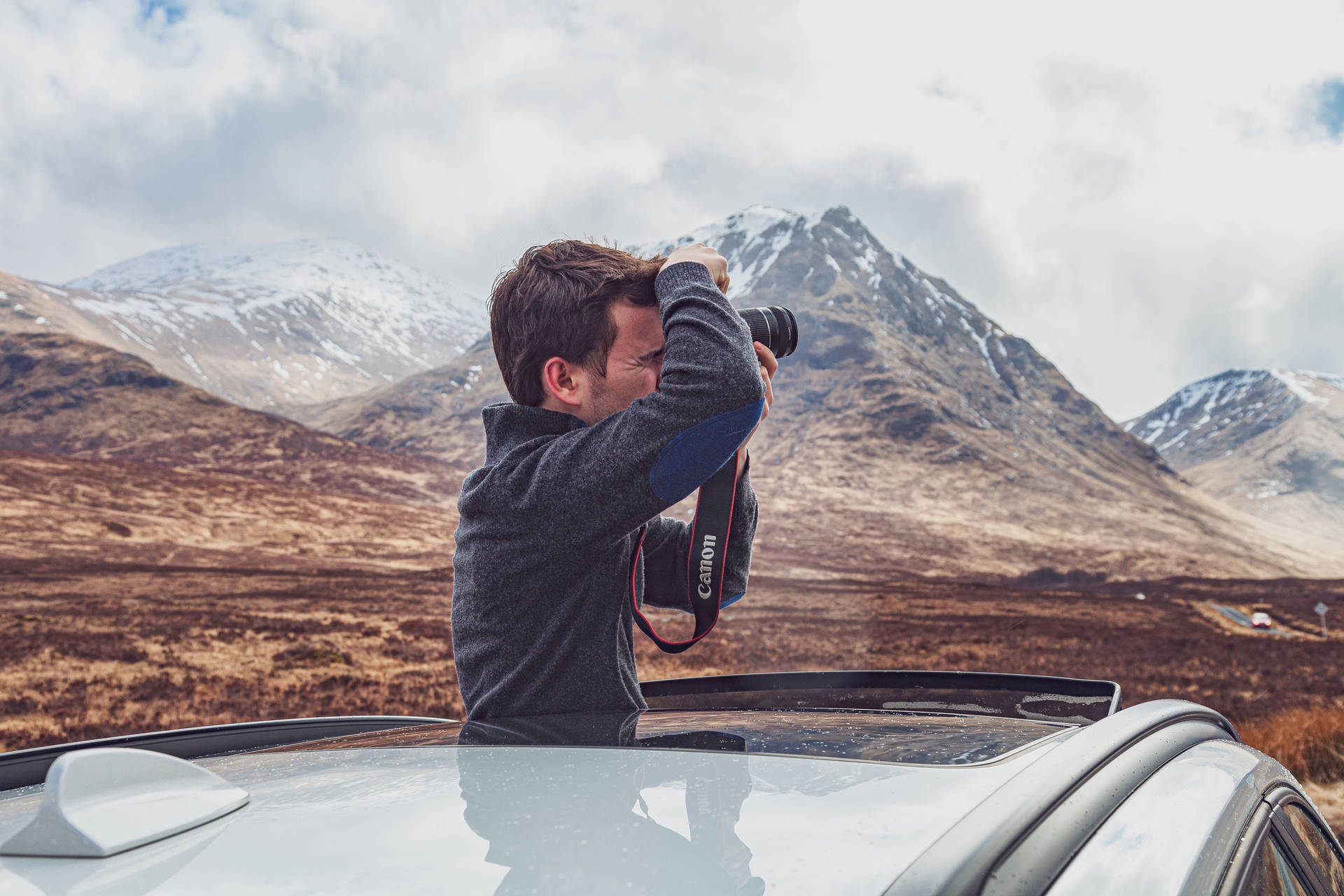 Man taking a photo during road trip wallpaper.