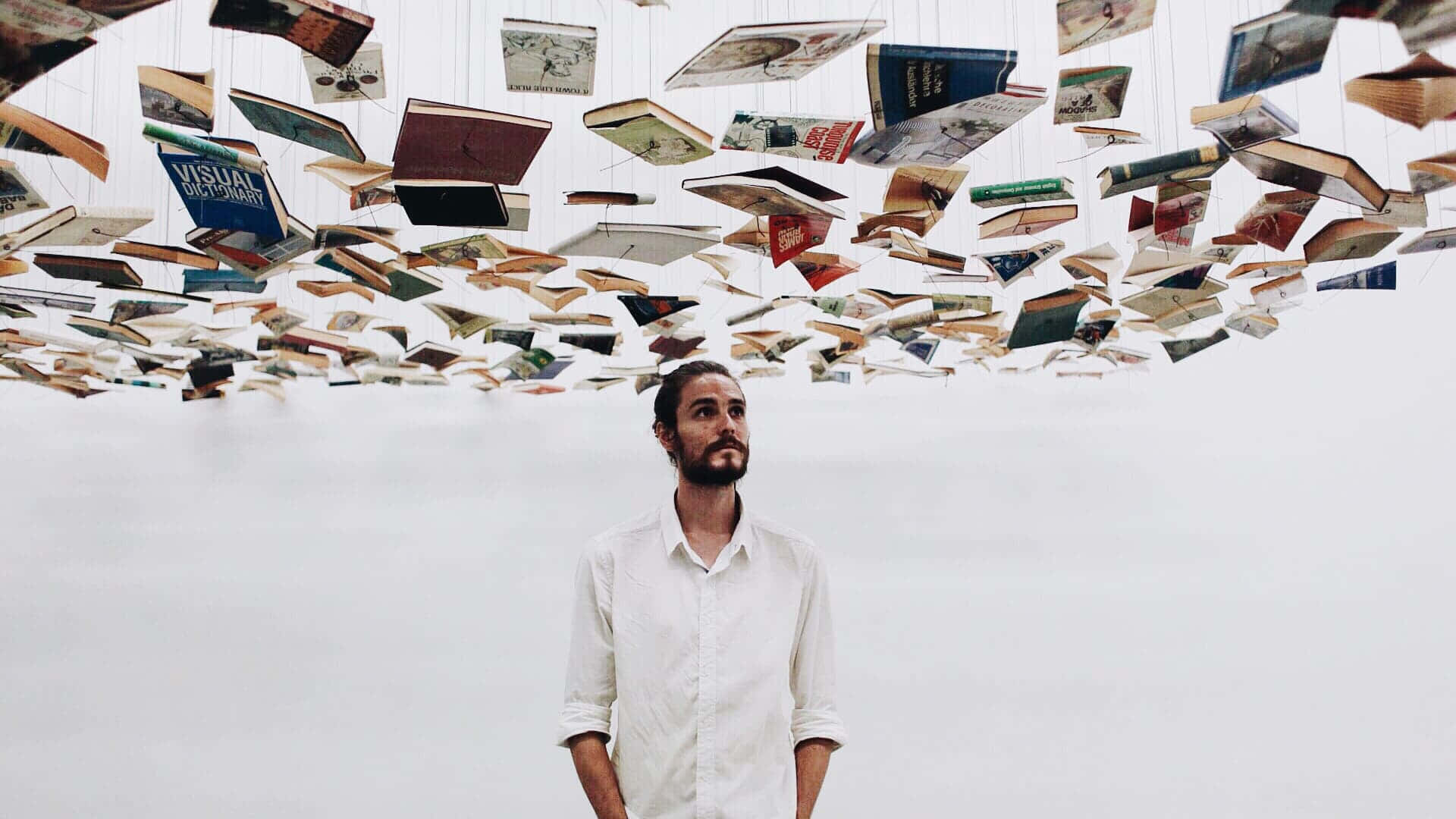Man Under Floating Books Wallpaper
