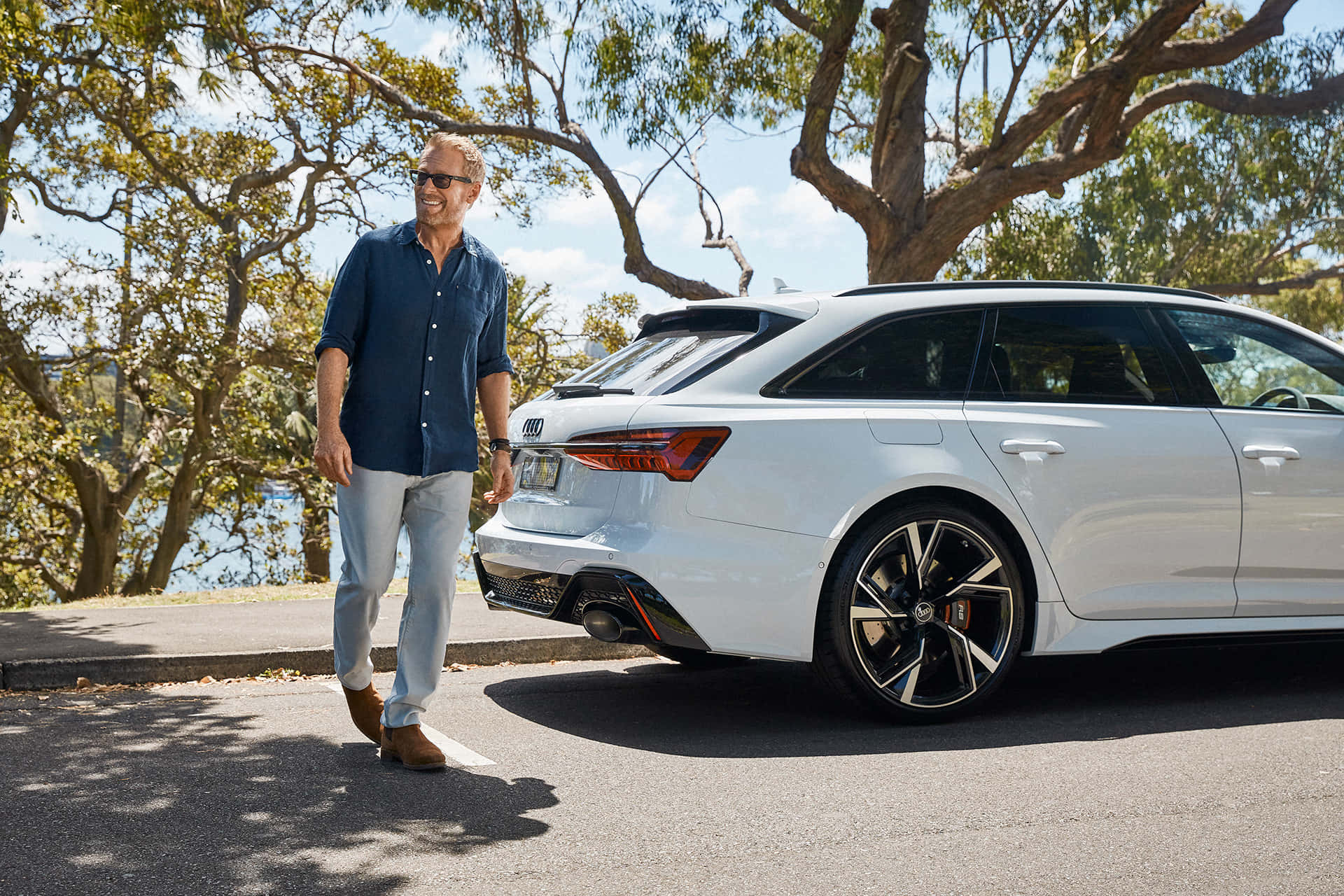 Man Walking Past White Car Outdoors Wallpaper