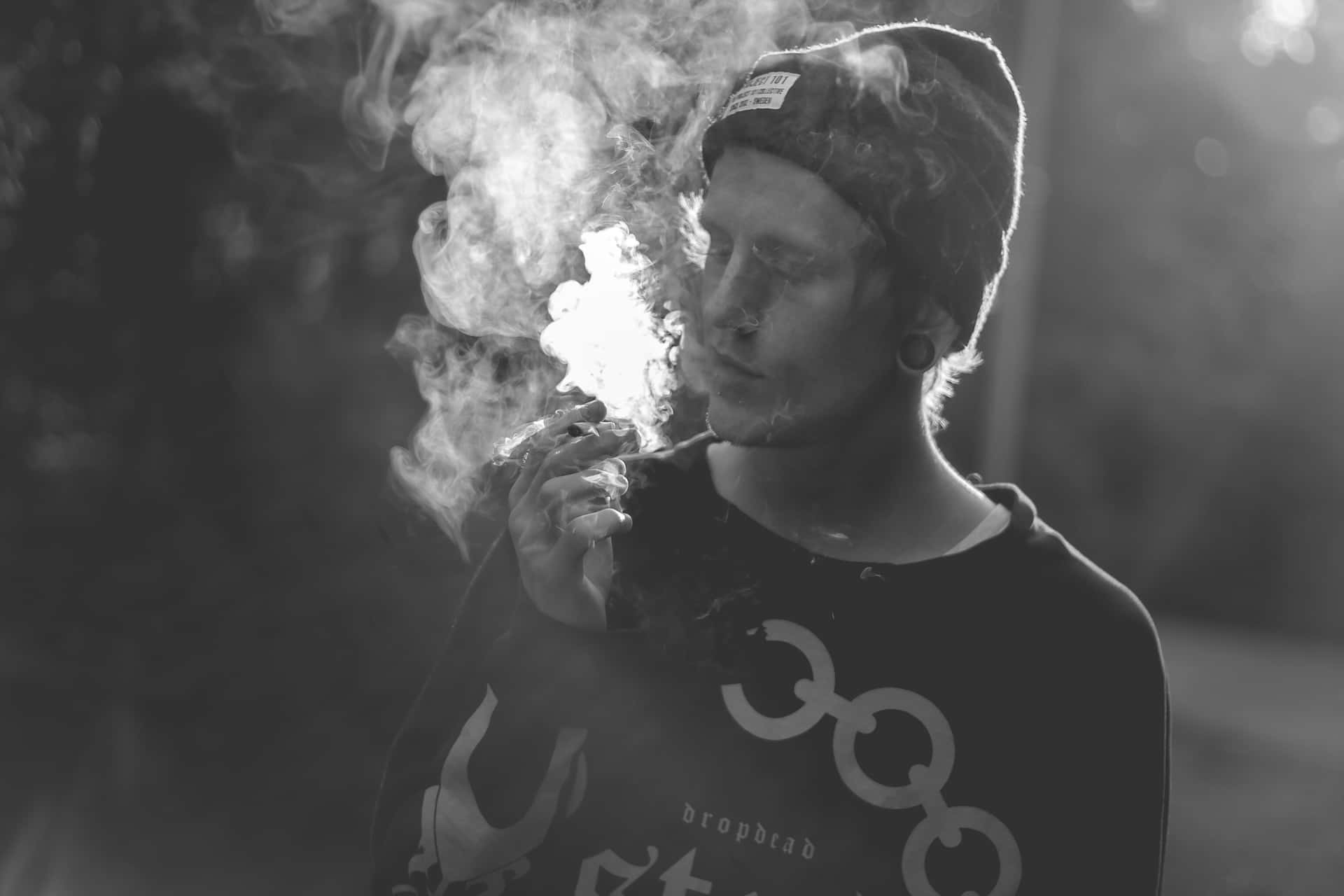 Hombrecon Capucha Fumando Un Porro. Fondo de pantalla