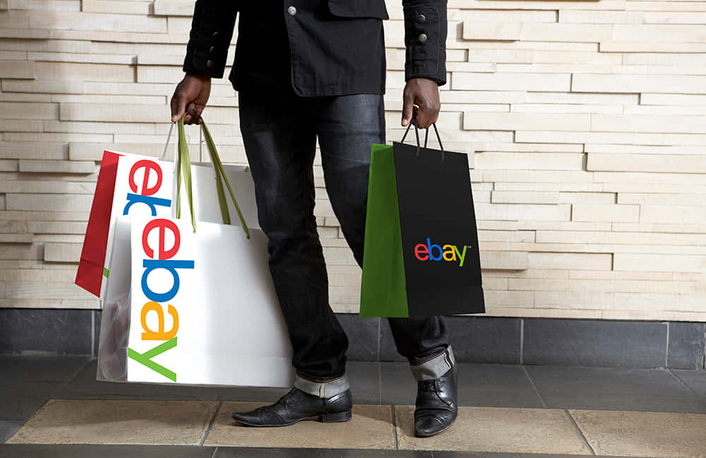 Hombrecon El Logotipo De Ebay Uk En Las Bolsas. Fondo de pantalla