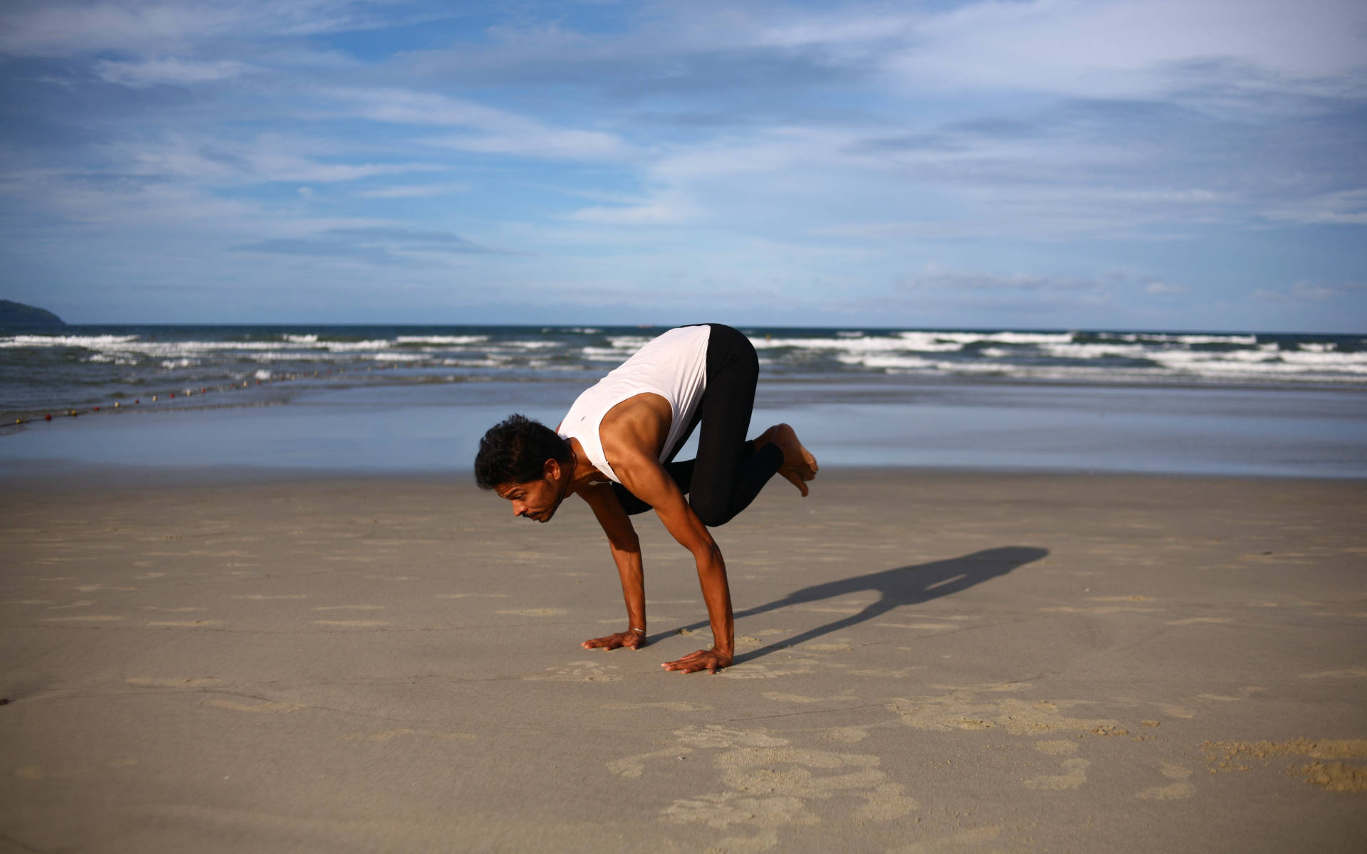 Hombrehaciendo Yoga En La Orilla De La Playa. Fondo de pantalla