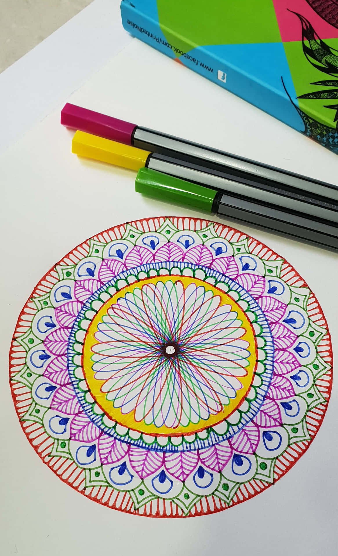A Mandala Coloring Page With Markers And A Book