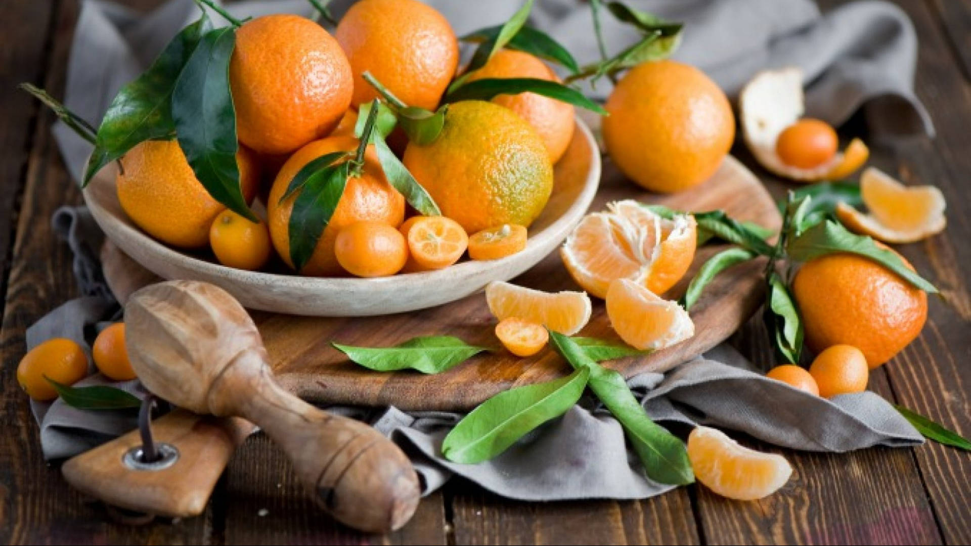 "Fresh Mandarin Oranges with a Wooden Juicer on a Table" Wallpaper