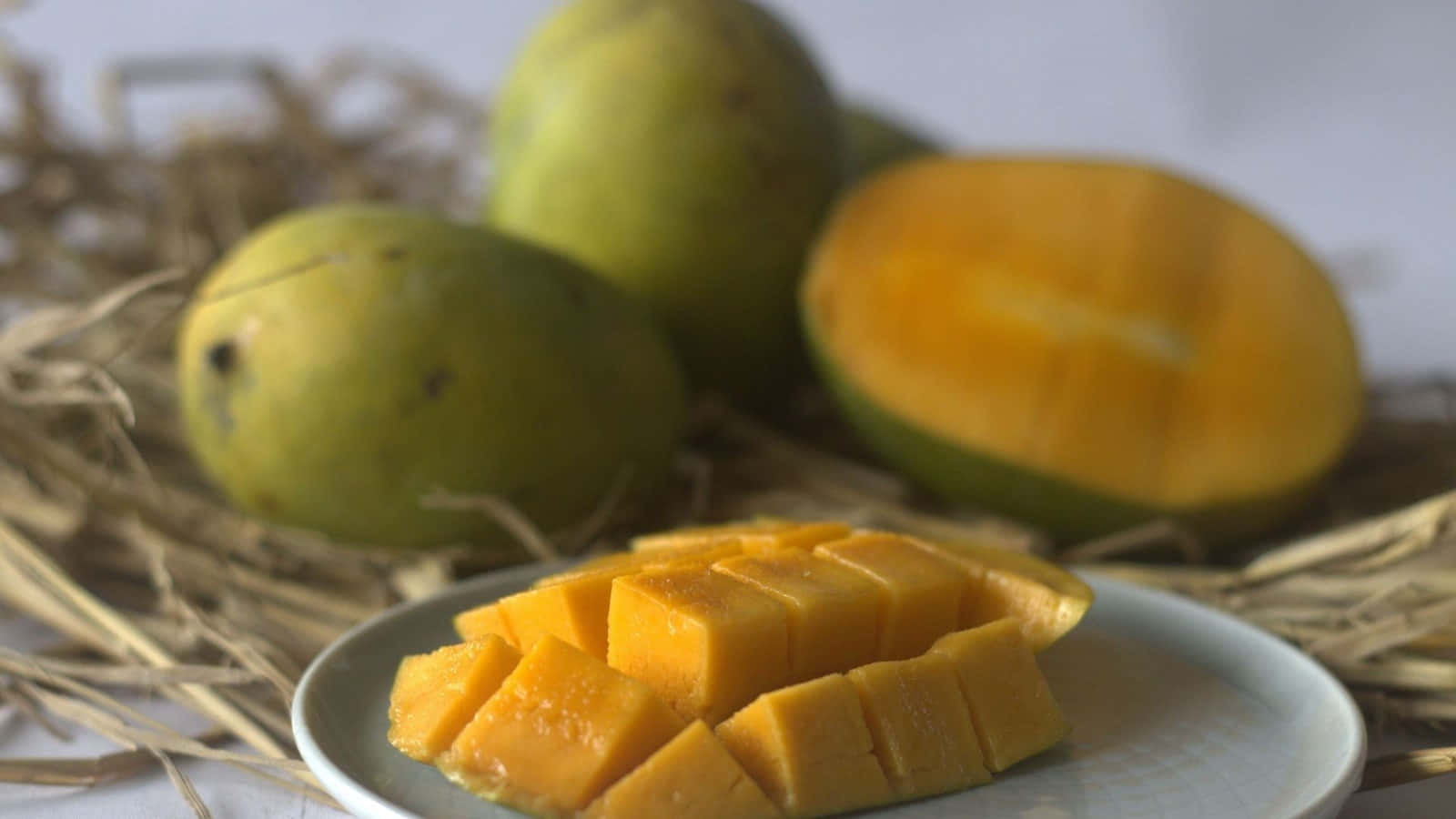 Mangoes On A Plate With Straw On The Side