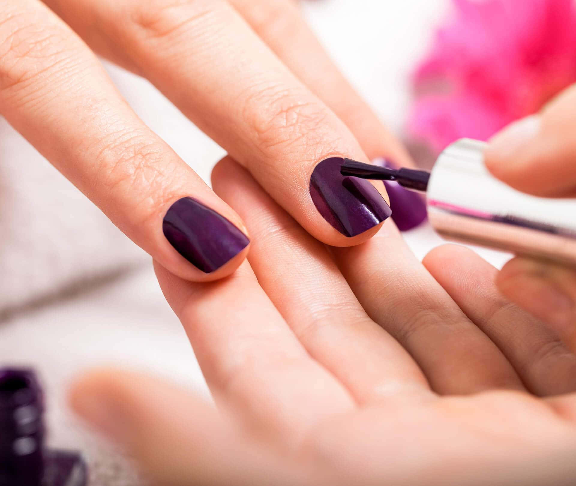 A Woman Getting Her Nails Done With Purple Nails