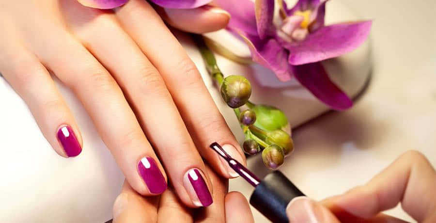 A Woman Is Getting Her Nails Done With Purple Nails