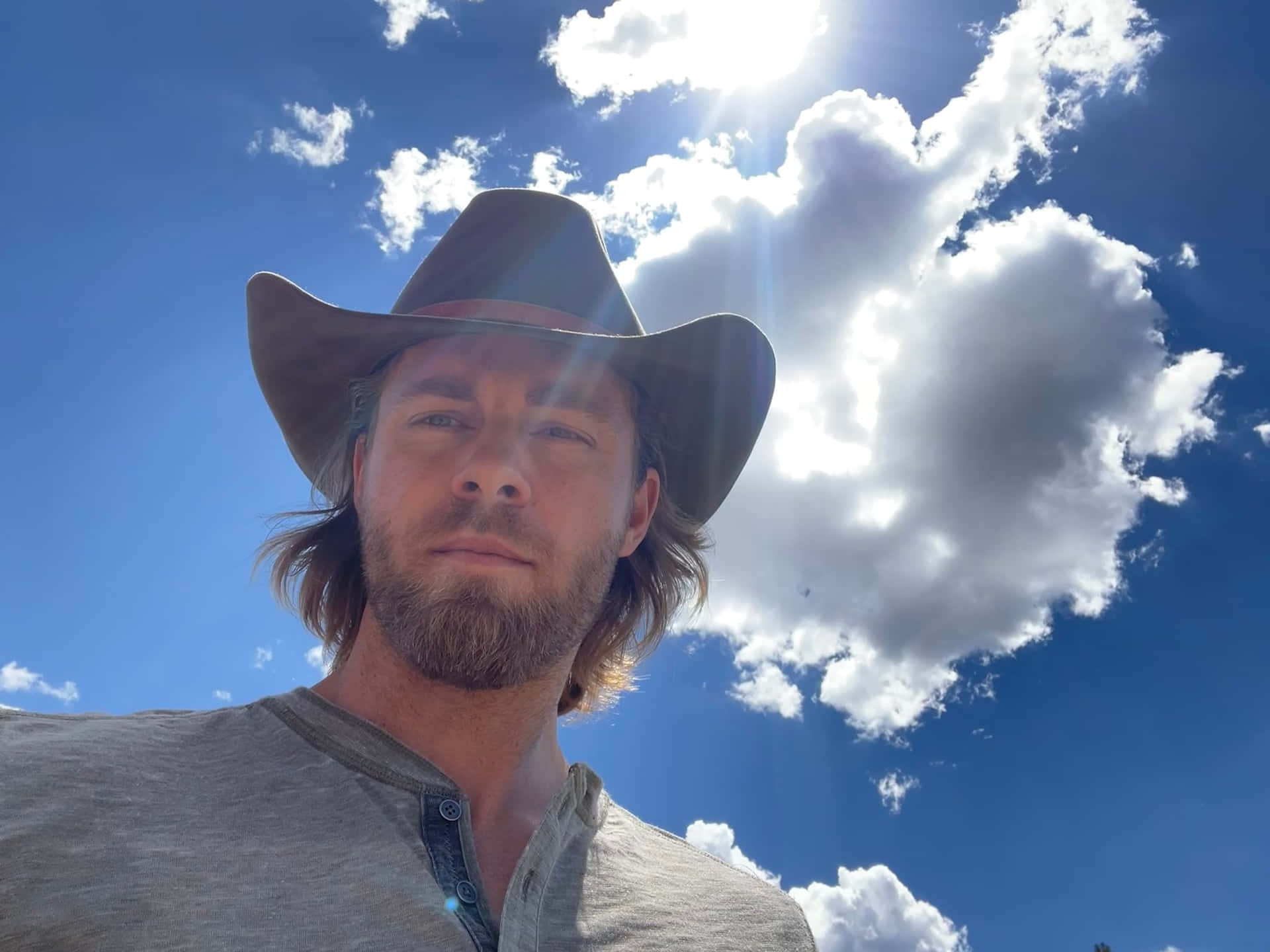 Manin Cowboy Hat Under Blue Sky Wallpaper