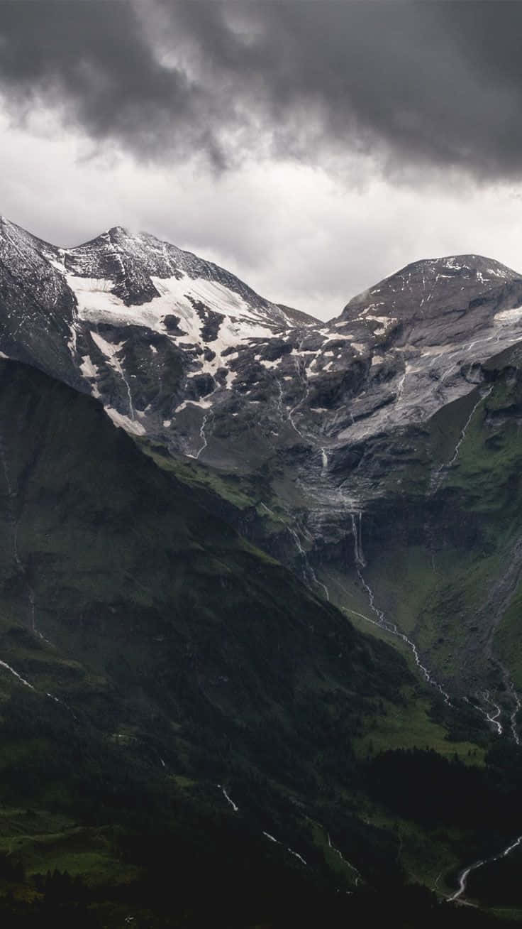 Einegebirgskette Mit Schneebedeckten Bergen Unter Einem Bewölkten Himmel Wallpaper