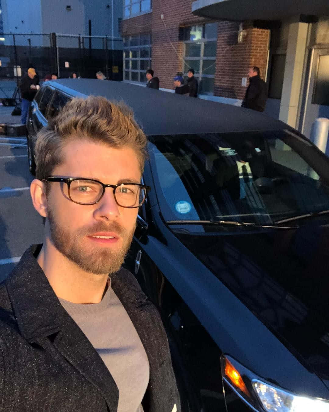 Manwith Glasses Selfie Near Black Car Wallpaper