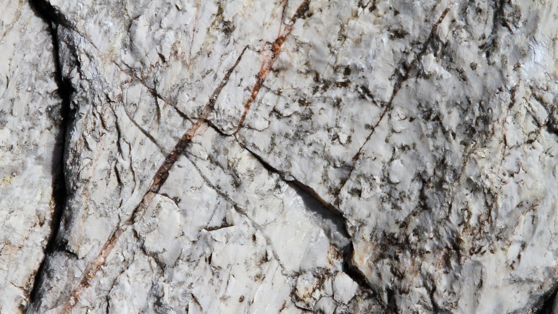 A Close Up Of A White Rock With A Black Streak Wallpaper