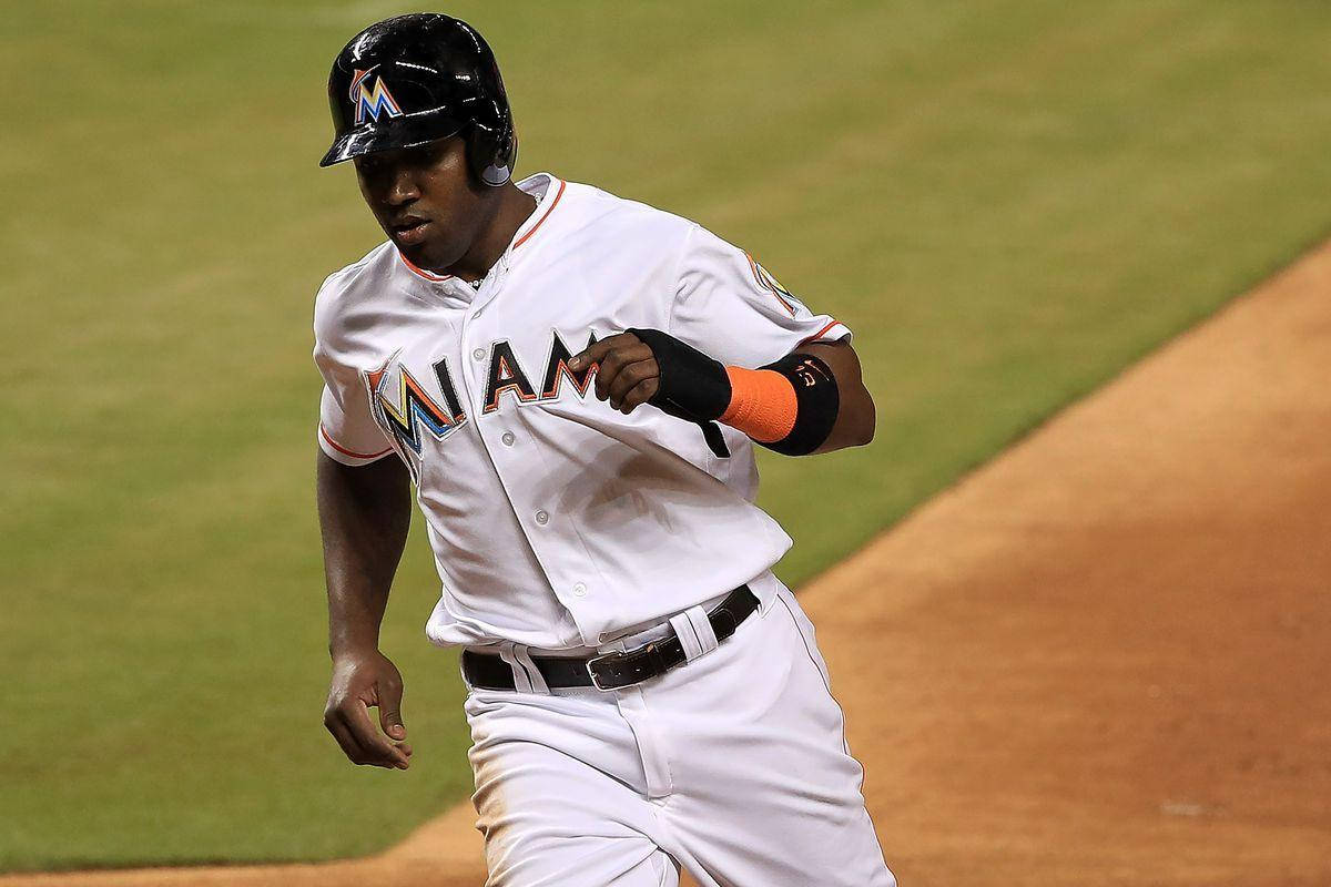 Marcell Ozuna Sprinting Across the Field in an Intense Baseball Game Wallpaper