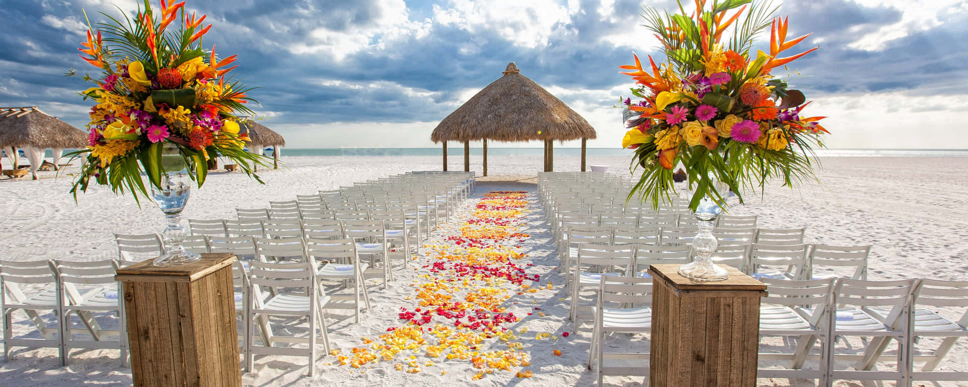 A Beach Wedding With Chairs And Flowers On The Beach