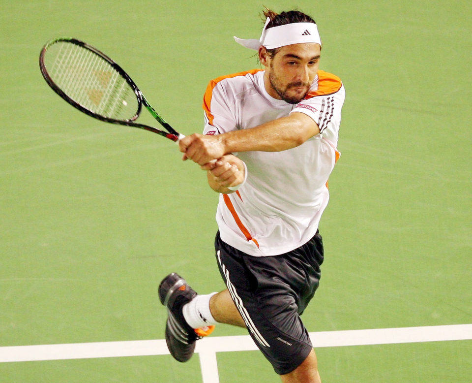 Marcos Baghdatis executing a two-handed grip on the tennis court. Wallpaper