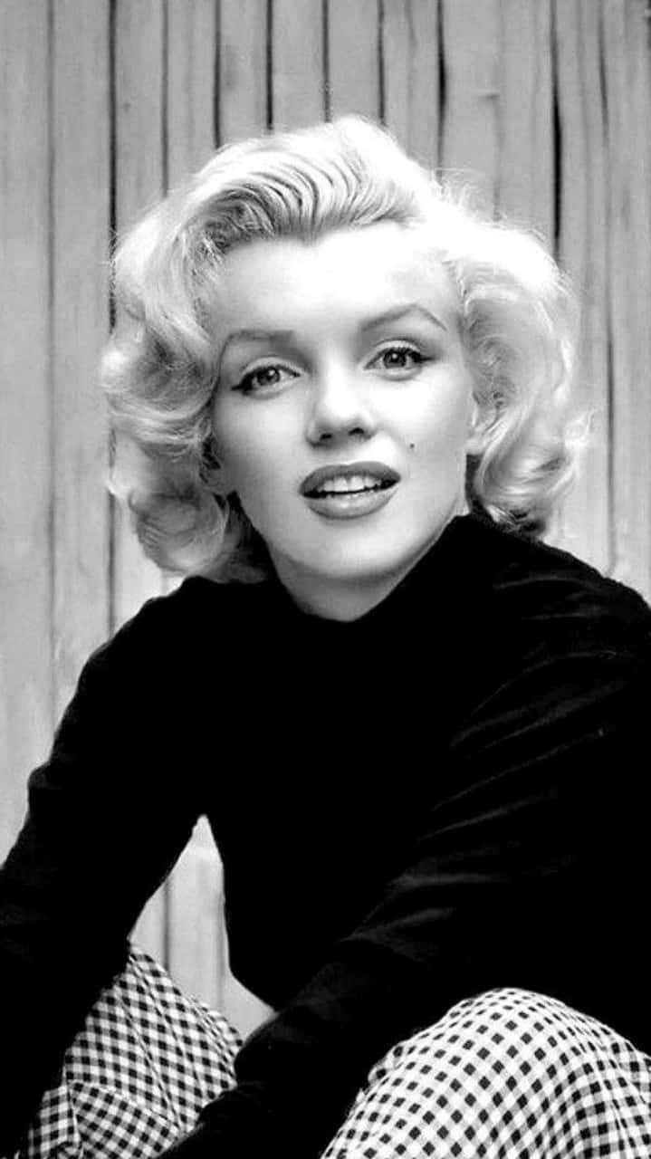 Marilyn Monroe i glamourøs pose med sin mobiltelefon Wallpaper